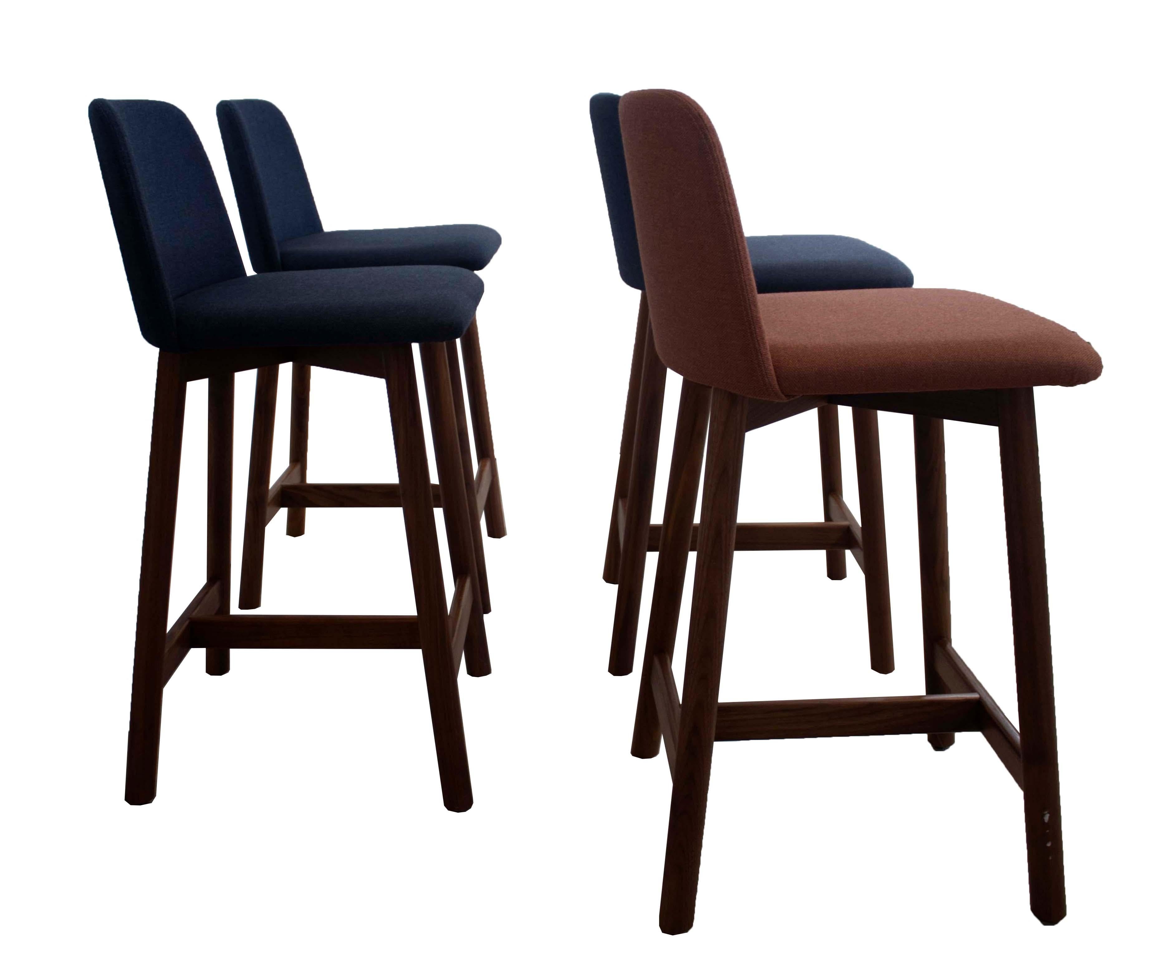Comfortable and sophisticated, this set of (4) Blu Dot Barstools are in excellent condition, including the upholstered seats. The seats and backs are upholstered (3) in navy blue and (1) in burnt orange - All have the same lovely walnut wood base