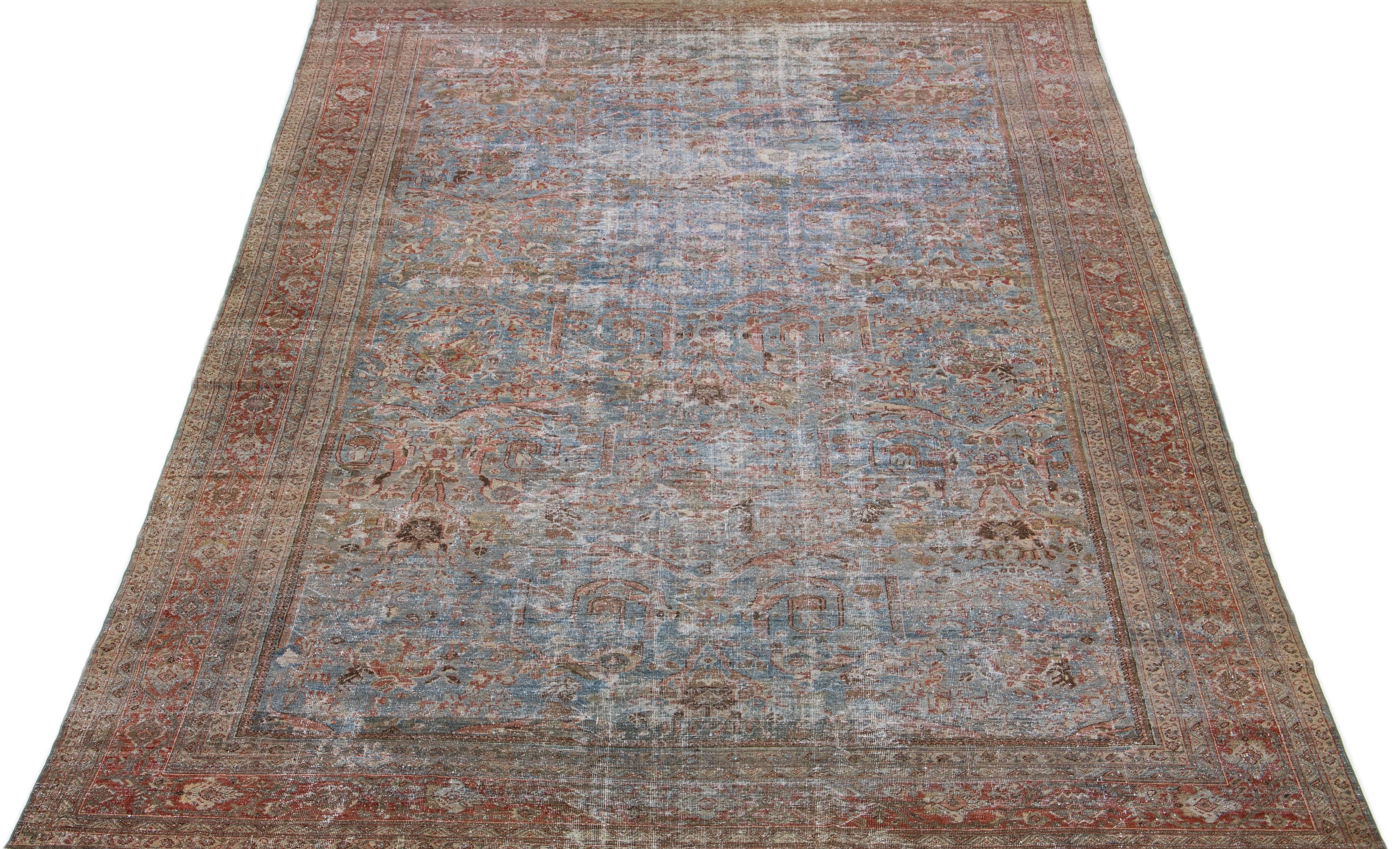Beautiful hand-knotted antique mahal wool rug with a blue color field. This Persian rug has rust and brown accent colors in an all-over floral design. 

This rug measures: 11'10