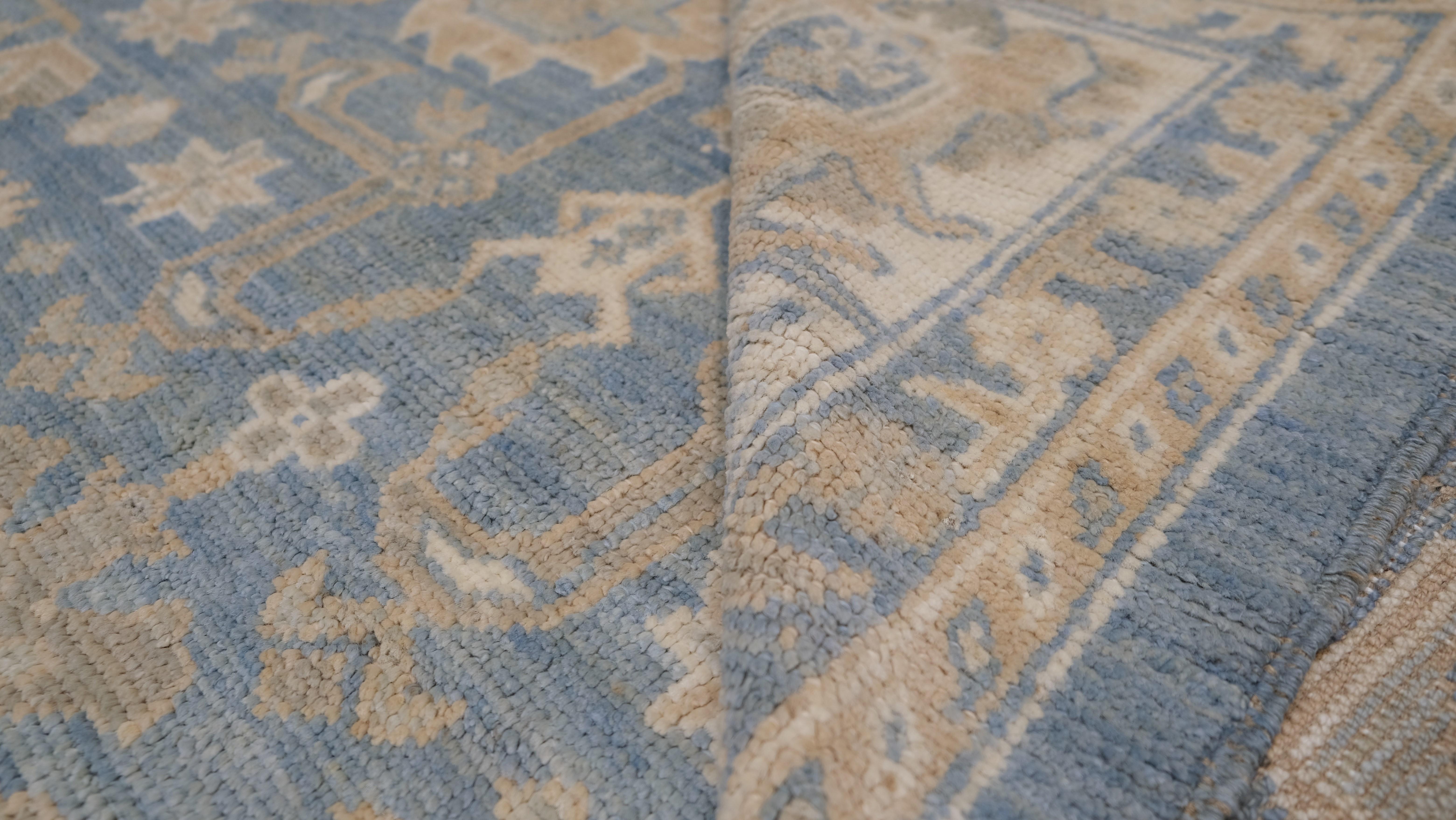 Tauchen Sie Ihren Raum in zeitlose Eleganz mit diesem exquisiten handgeknüpften Wollteppich. Mit einem klassischen Blumenmotiv in beruhigenden Blau- und Beigetönen zeigt dieser Teppich aufwändige Medaillons und dekorative Bordüren, die