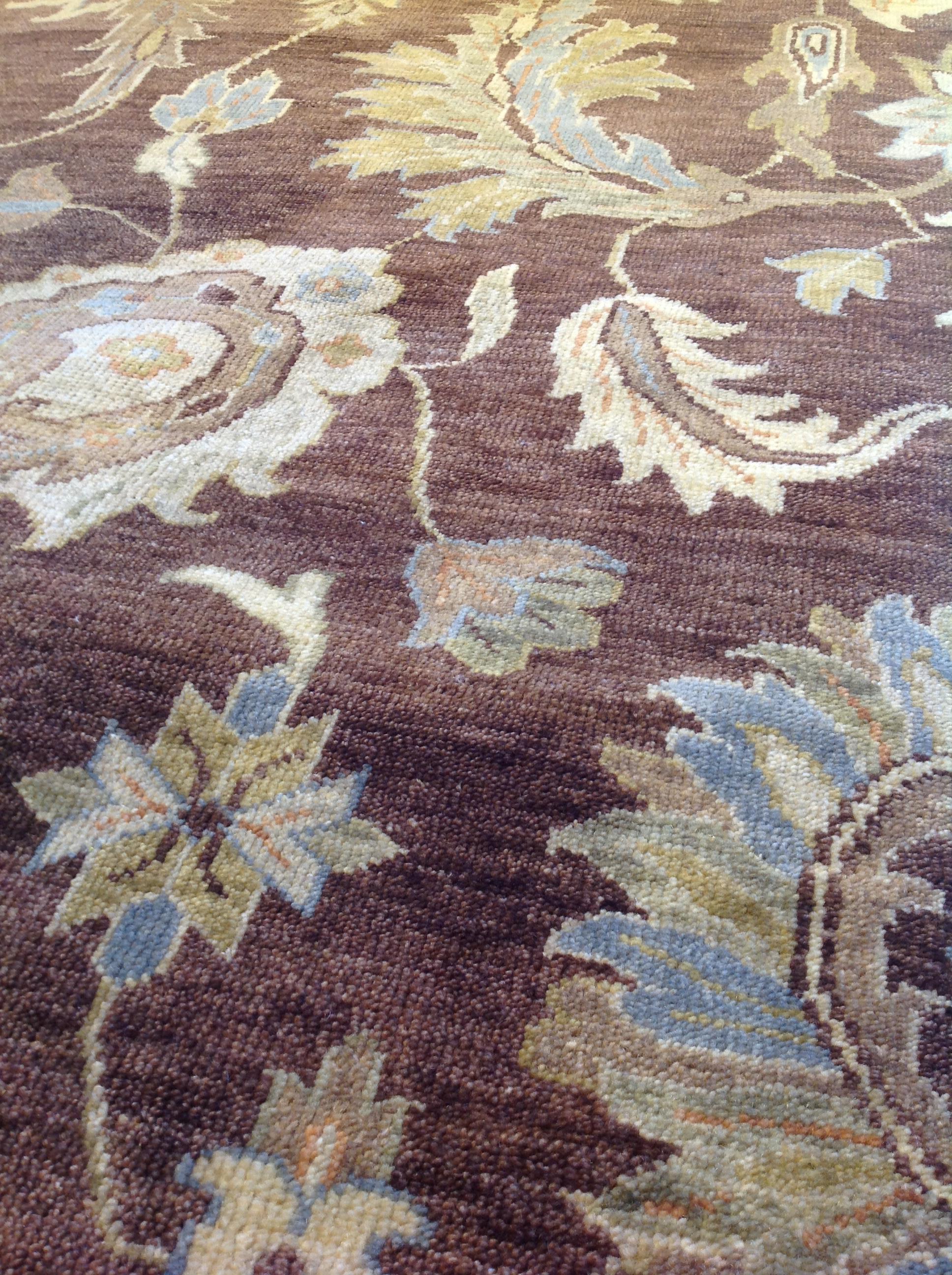 Oushak rugs are known for displaying a calm, tame look but the use of bold brown and blue in this present-day example is anything but boring. A wonderfully balanced floral center panel and contrasting border bring tradition seamlessly into today's