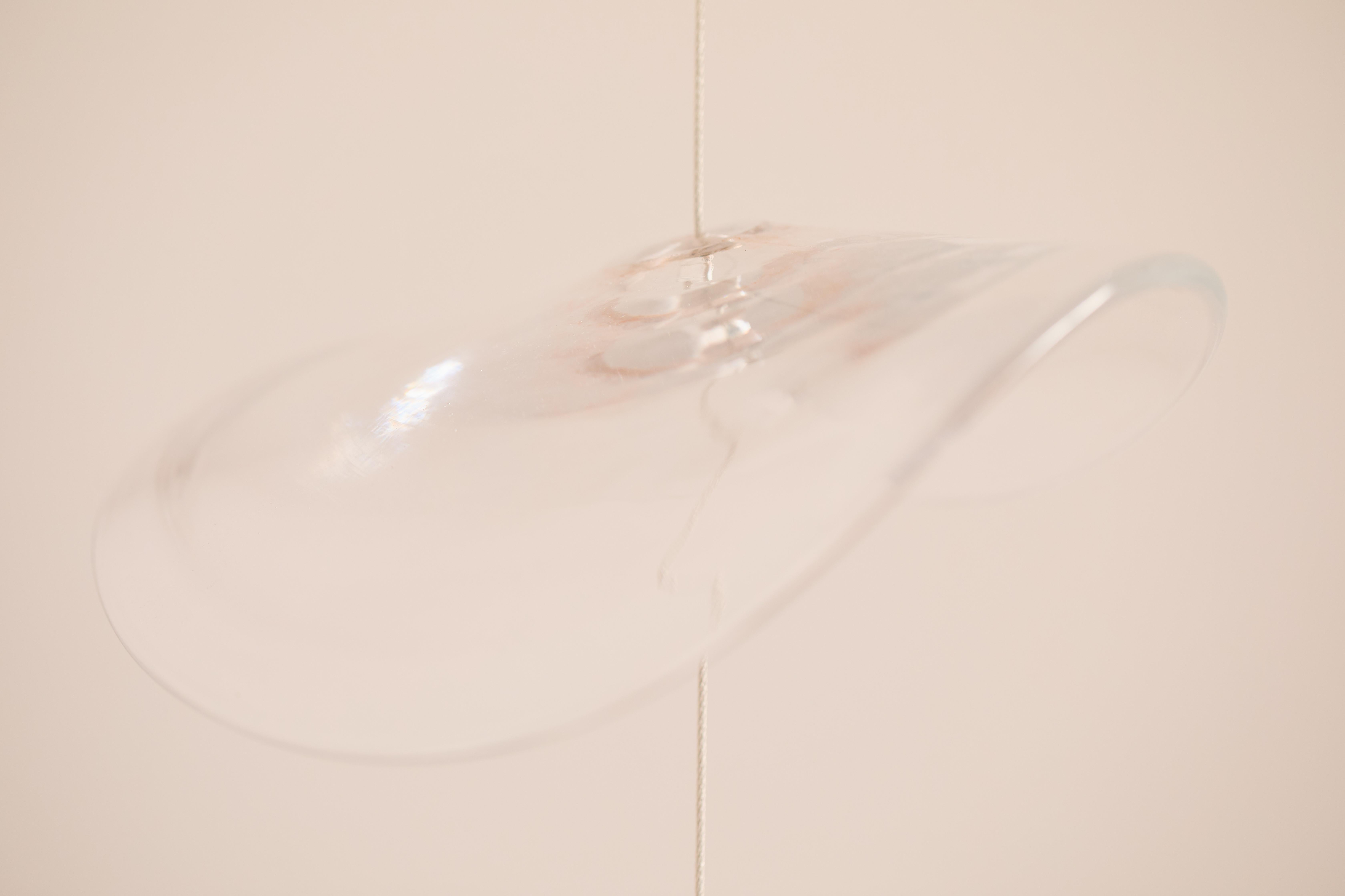 A delicate dance of light and color—this handcrafted glass sculpture transforms any space into a symphony of reflections. Transparent and colored glass discs, each uniquely artisan-made, are elegantly suspended on a stainless steel cable, creating a