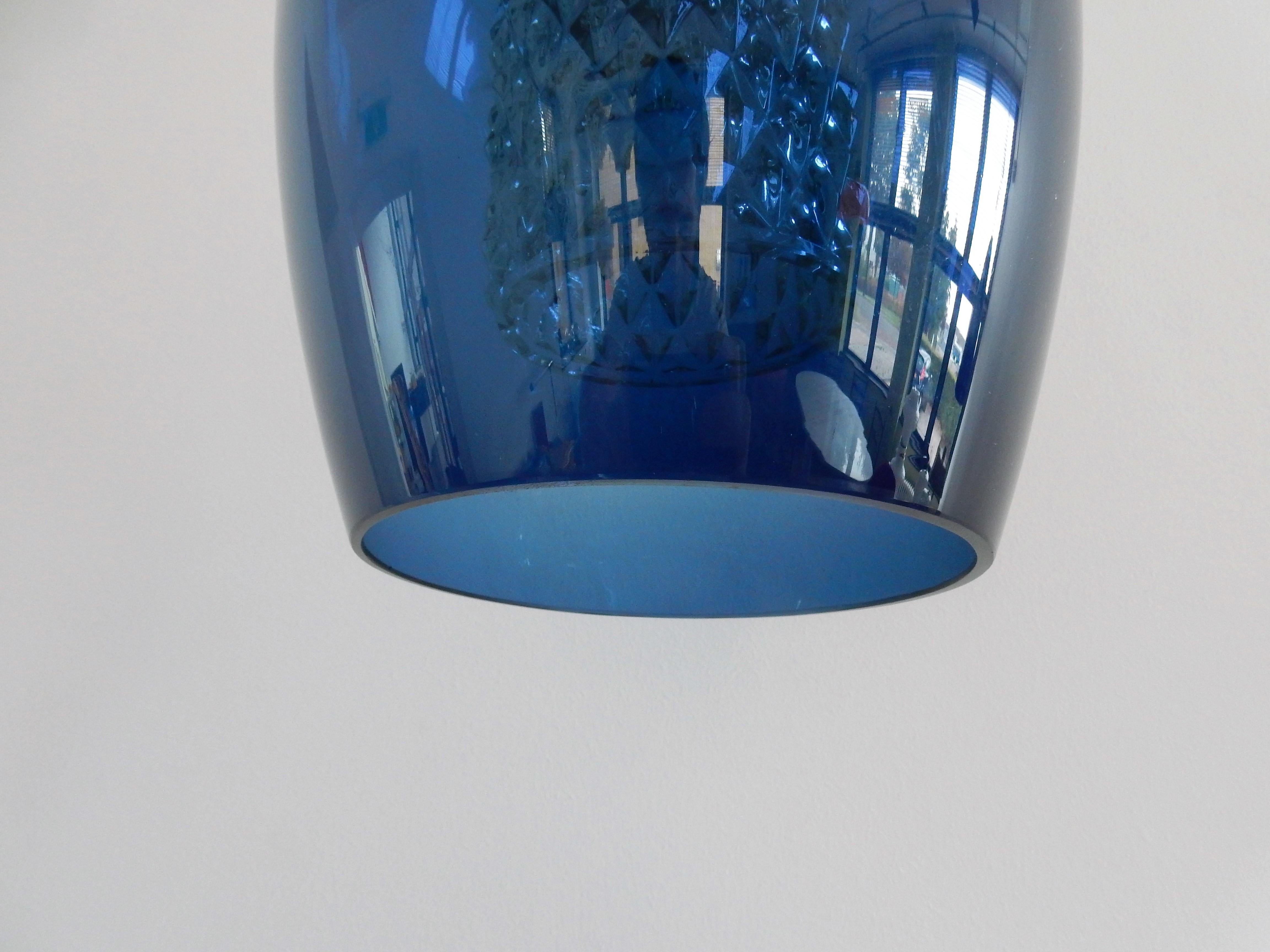 This beautiful and elegant pendant lamp has a large blue glass exterior shade and a smaller patterned clear glass interior shade. It could very well be a lamp by Carl Fagerlund for Orrefors. 