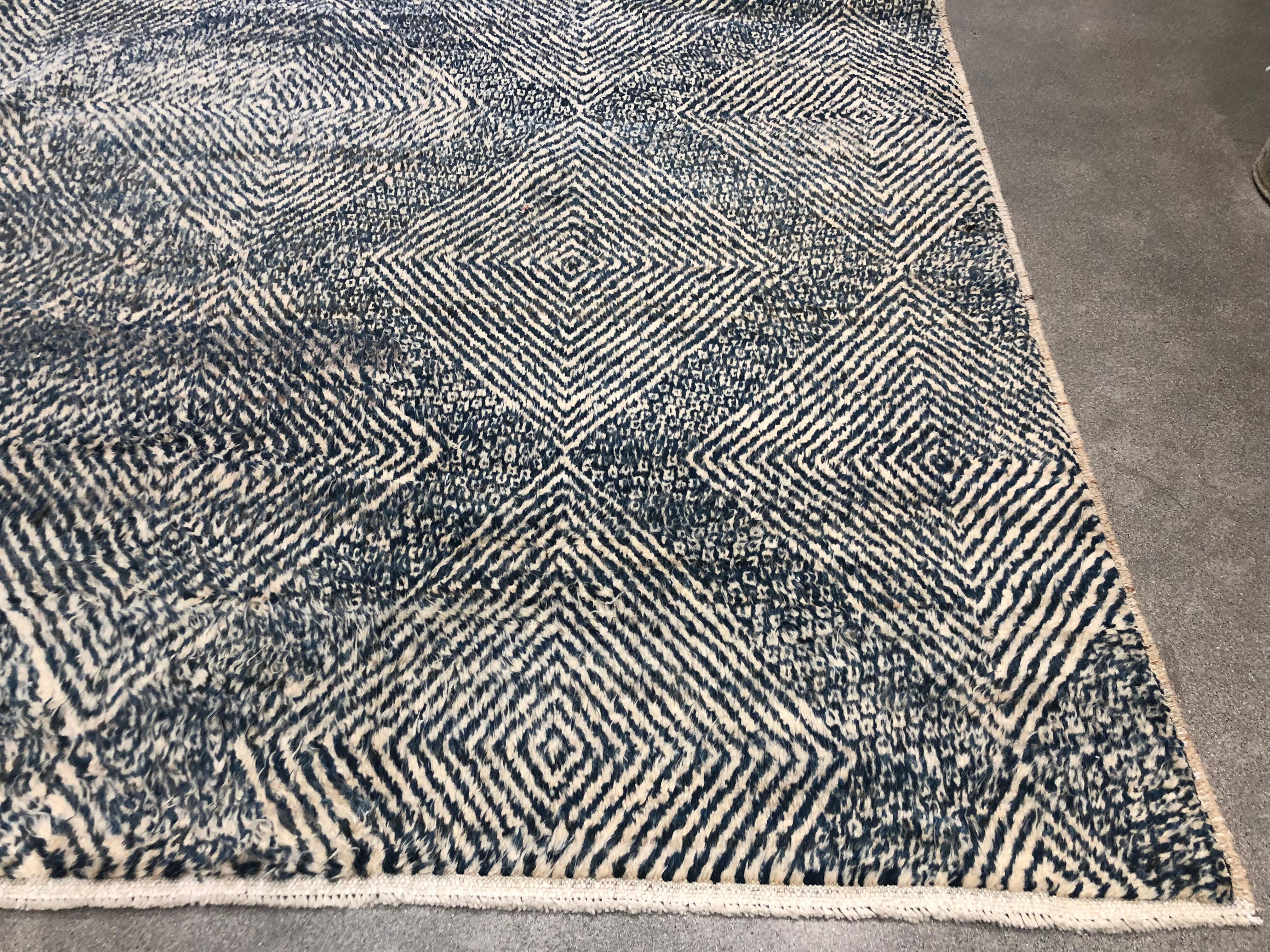 This blue and cream colored diamond design rug is handmade and hand knotted made in Pakistani. This rug has a slight plushiness that is similar to a Moroccan rug. 


