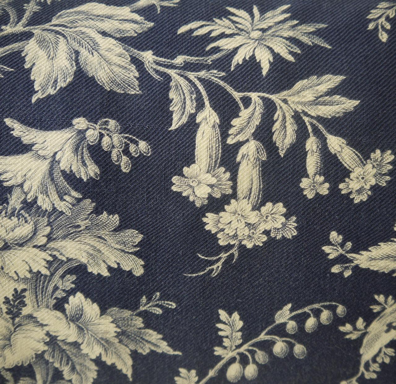 Later 19th century French printed cushion printed with a design of exotic flowers and meandering branches on textured cotton. With 19th century French cotton tassels at each corner. Self-backed and slip-stitched closed with a duck feather insert.