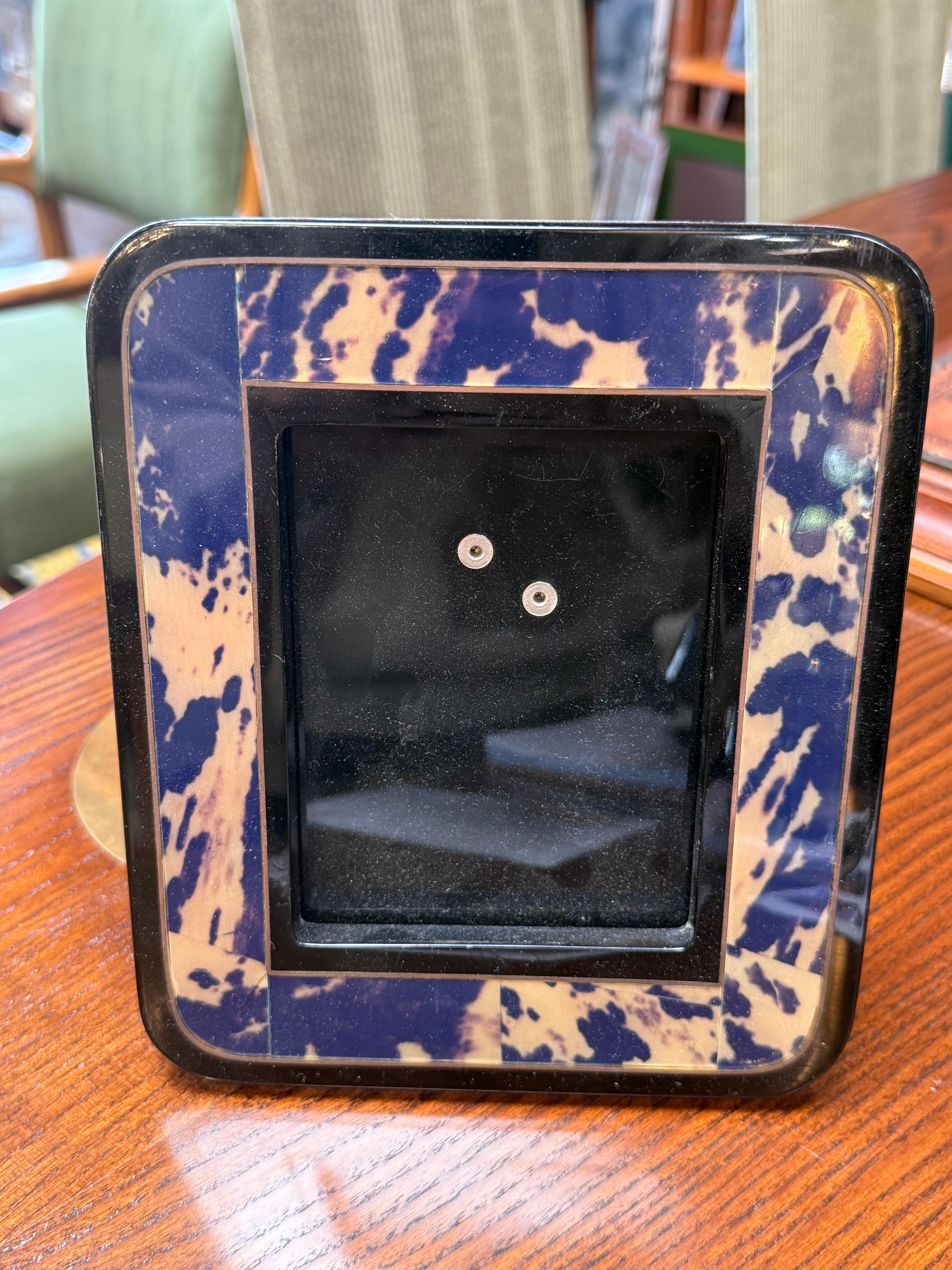 L'élégant cadre photo en résine marbrée bleu et crème ajoute une touche de sophistication moderne à tout décor. Le cadre présente un motif marbré audacieux avec des nuances de bleu profond et d'ivoire, encadré par un contour noir élégant pour une