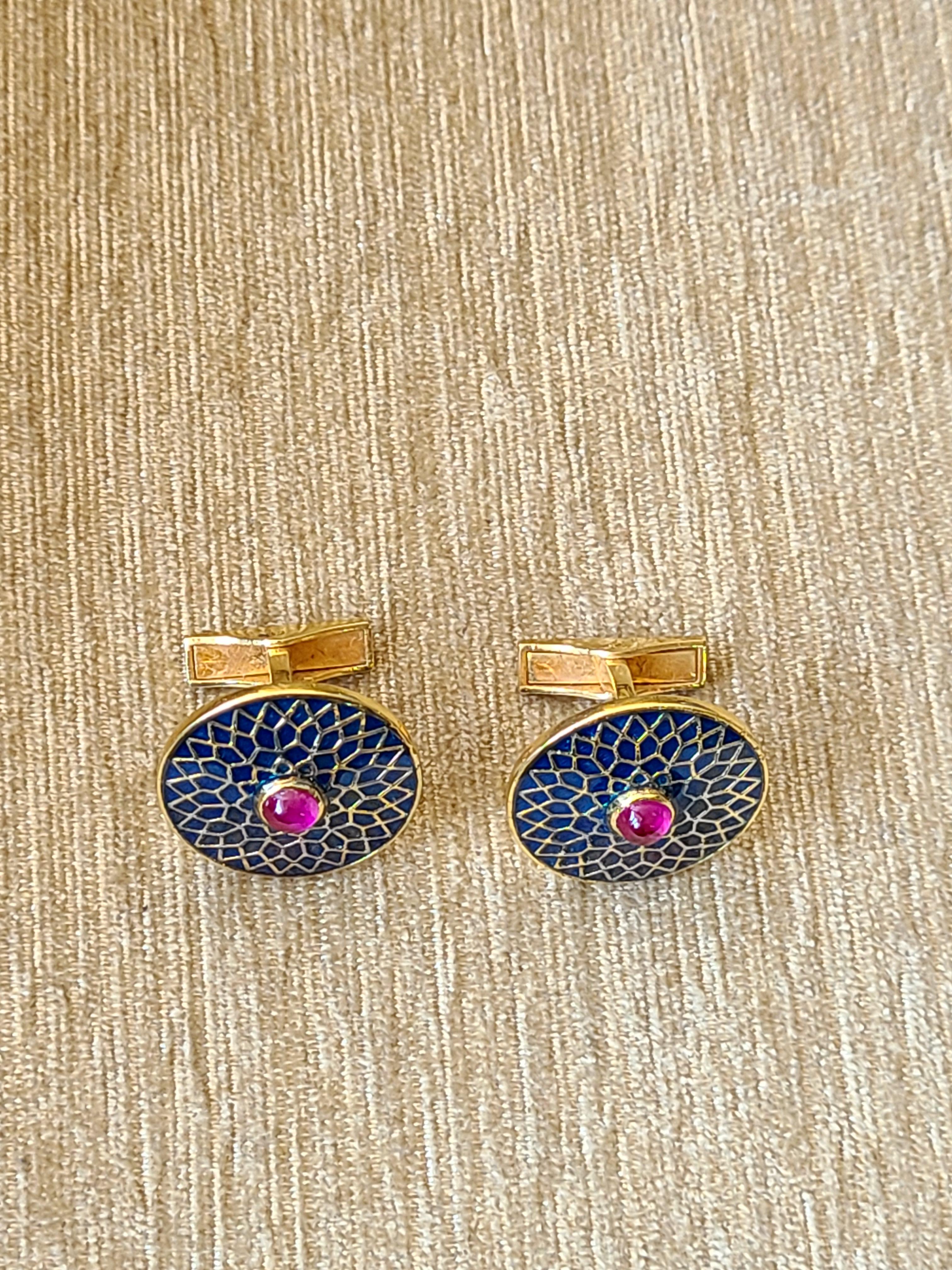 A gorgeous pair of cufflinks set with ruby in centre and finished with high quality blue and gold enamel made in 14k yellow gold. The net gold weight is 12.48 grams with ruby cabochon weight of .78 carats. The cufflinks dimension in cm 2 x 2.1 x 2.1