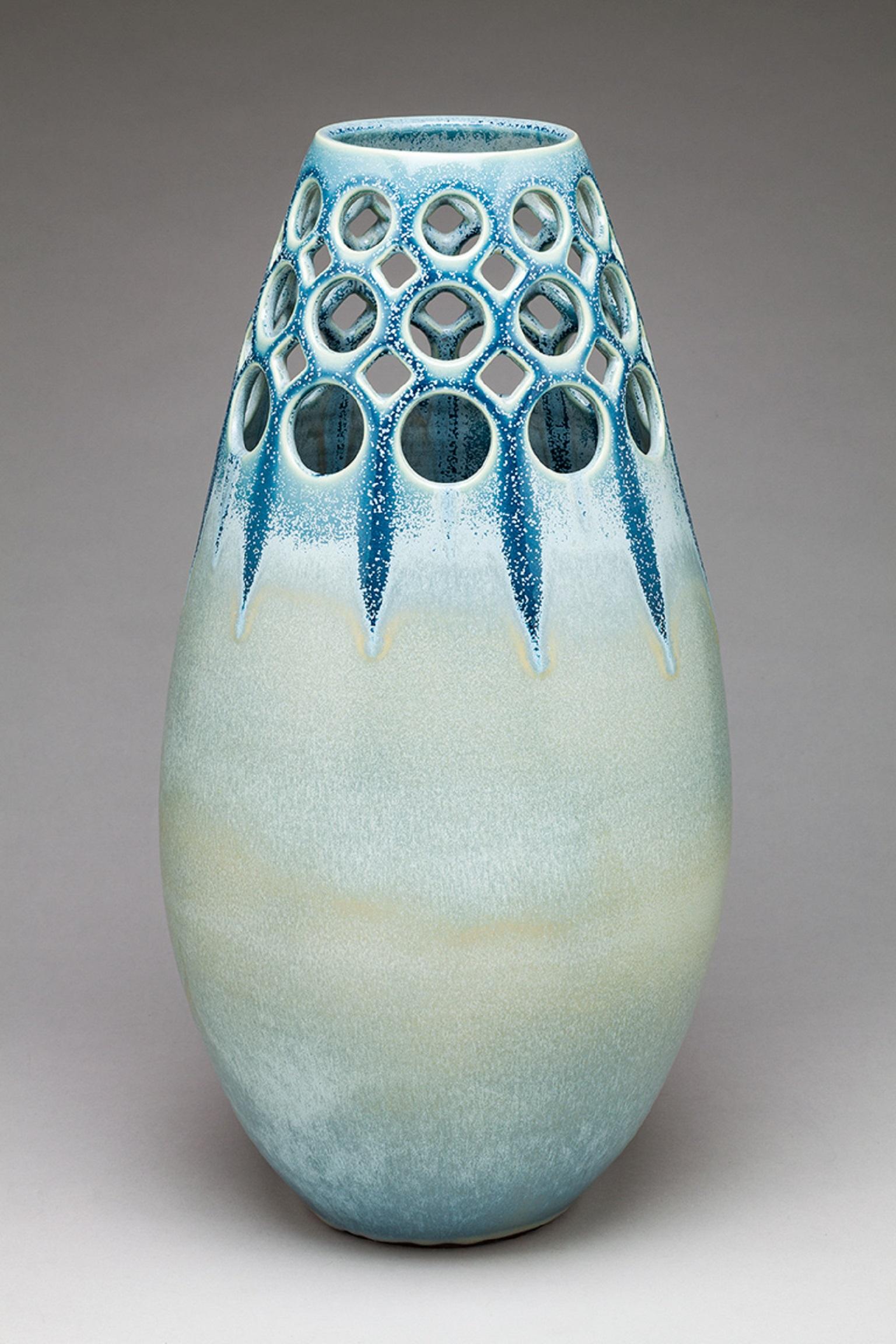 Inspired by Mid-Century Modern design, the vase is wheel thrown and hand pierced stoneware with a crystaline satin glaze. The glaze is slow cooled to allow crystal formations to grow in the surface of the glaze. Because of this, glaze results may