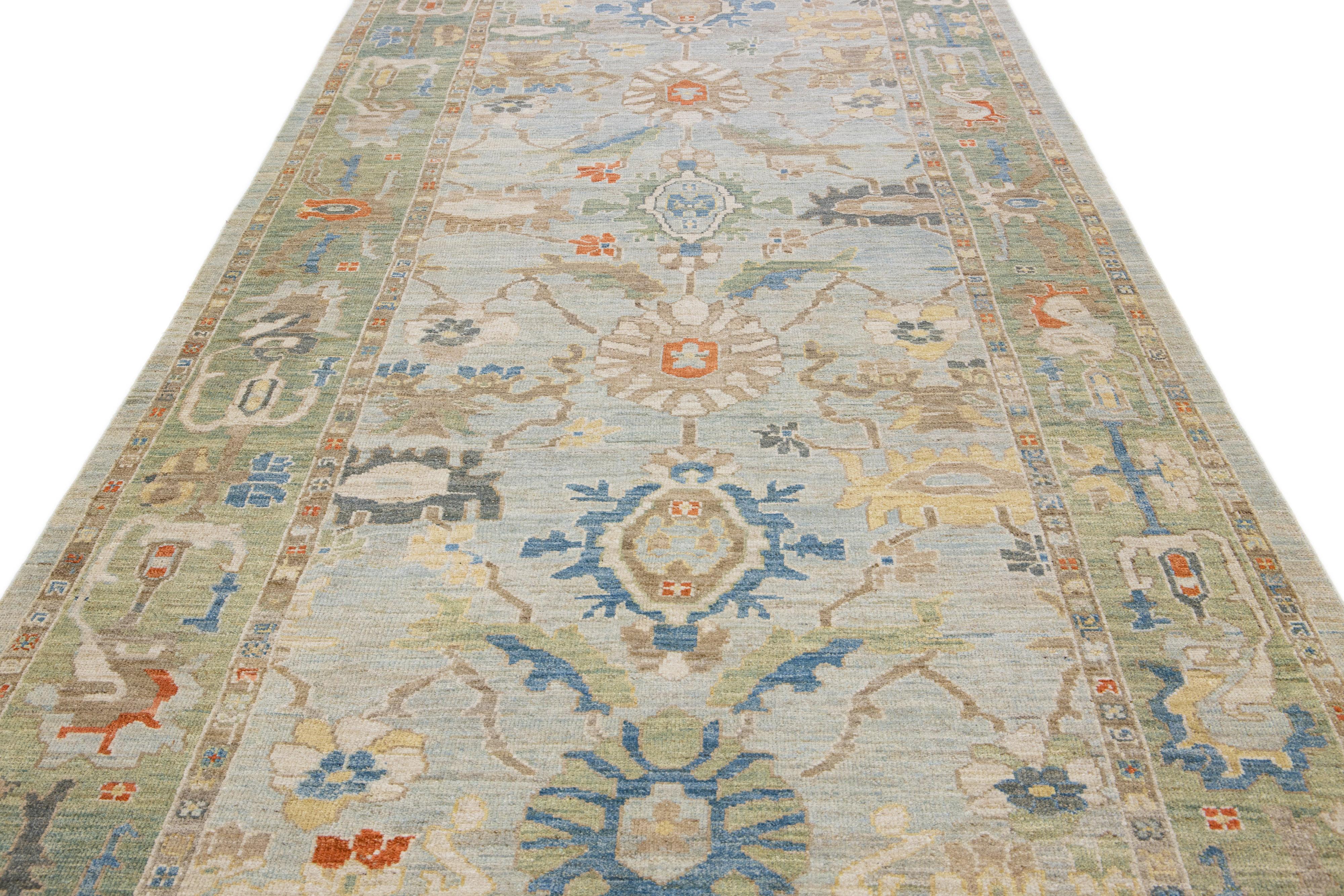 Questa moderna reinterpretazione del design senza tempo di Sultanabad Rugs si manifesta in un tappeto in lana squisitamente annodato a mano, che risplende nella sua sorprendente tonalità di azzurro. Un intricato bordo verde delinea il ricamo