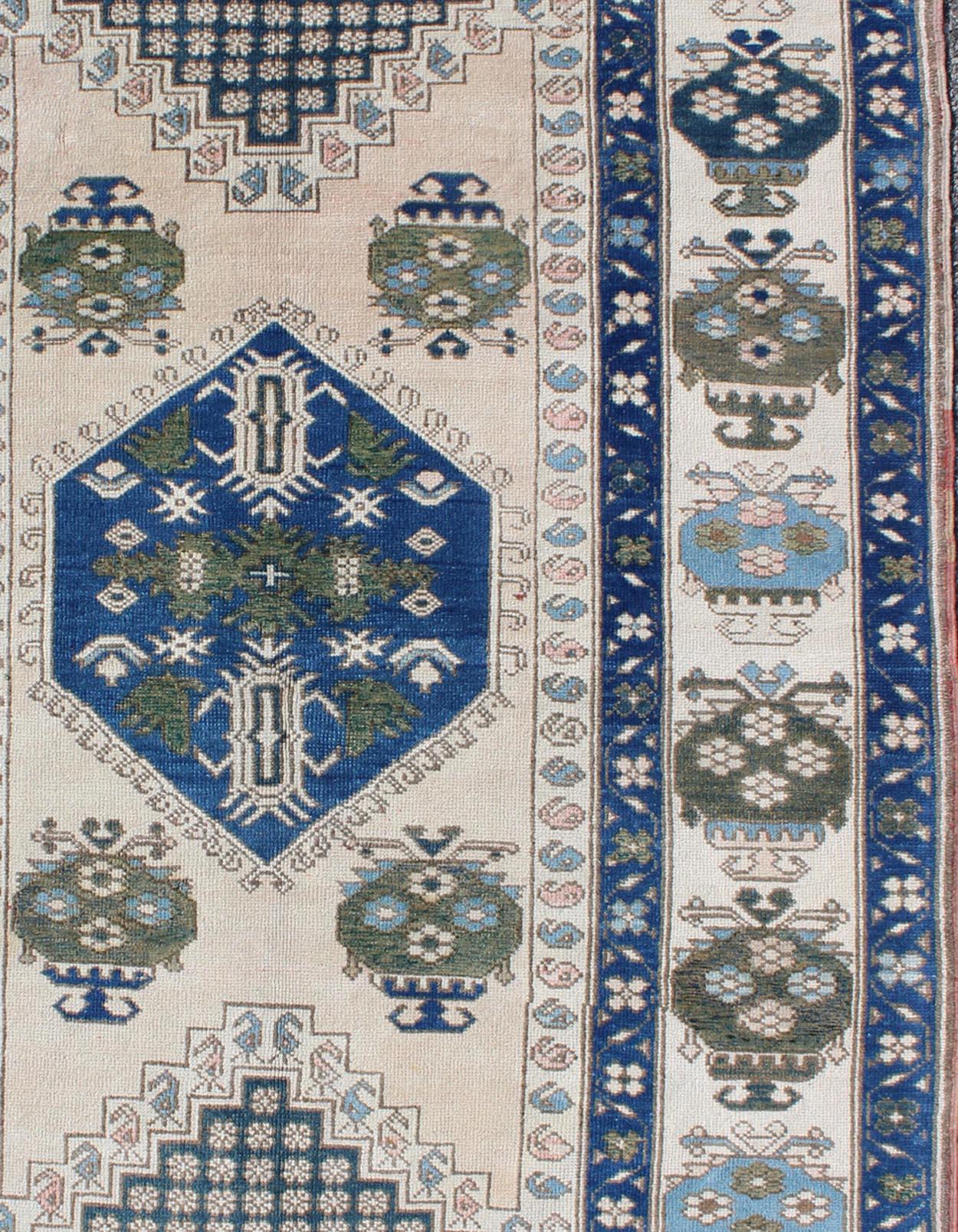 Vintage Oushak carpet in geometric design with variety of blue colors, green, taupe, tan and ivory.
 rug/EN-165827, country of origin / type: Turkey / Oushak, circa 1950

This vintage Oushak carpet from mid-20th century Turkey features a traditional