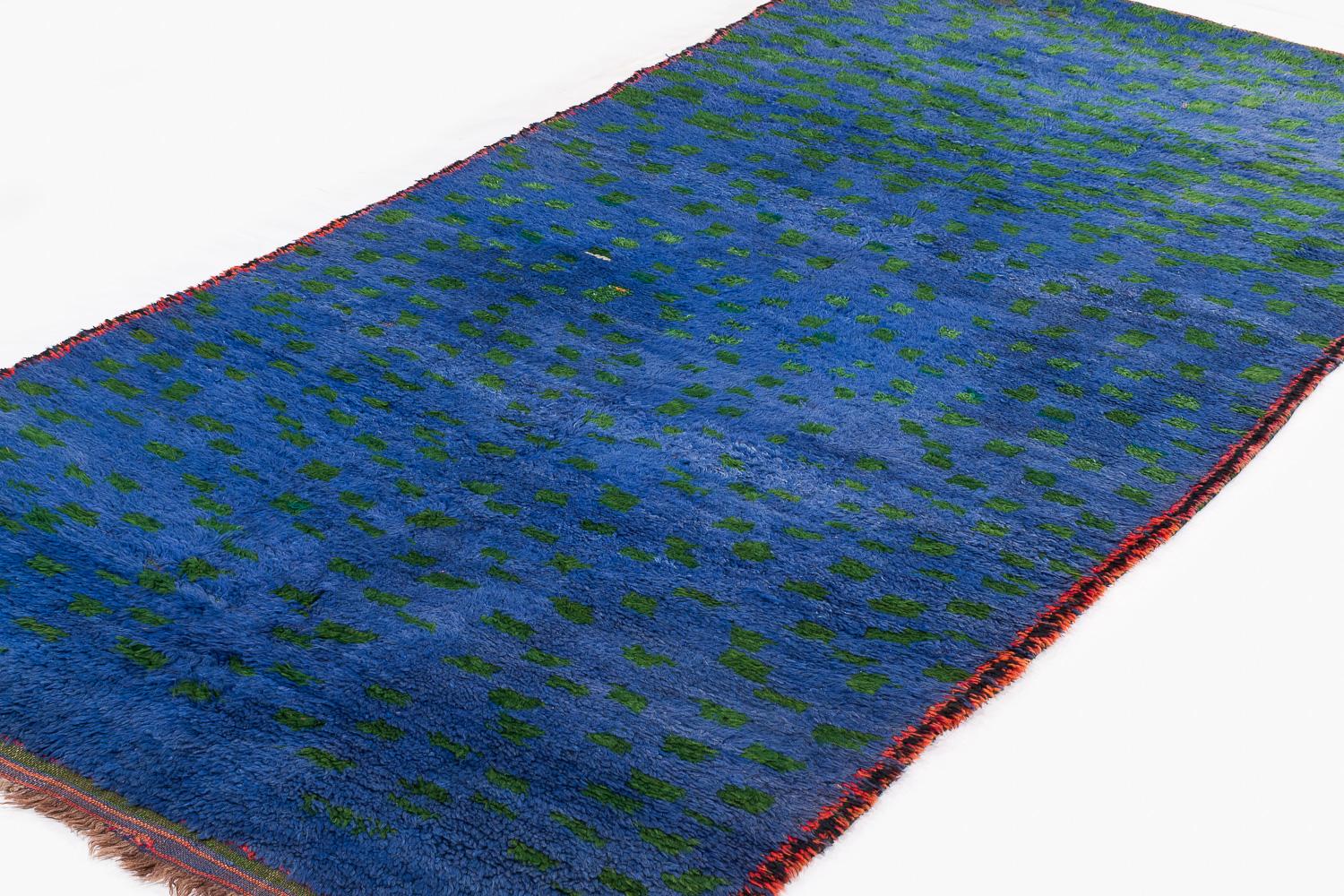 This antique vintage Moroccan rug came from the Beni Mguild tribe from the central middle Atlas mountains. This rug features beautiful dye, exhibiting great color and movement. It was an authentic Berber piece, originally commissioned in the 1960s