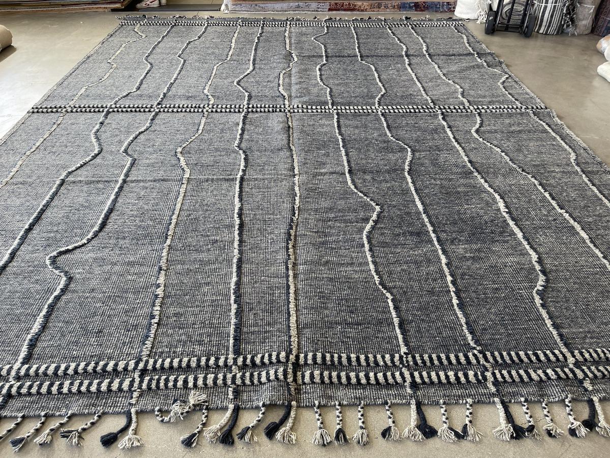 Linien aus geschnittenen Fasern vor einem dicht gewebten Hintergrund sorgen für visuelles Interesse an einem äußerst strapazierfähigen Teppich. Wolle und Baumwolle. Hergestellt in Indien mit natürlichen Farbstoffen. Auch in 10 x 14 erhältlich.