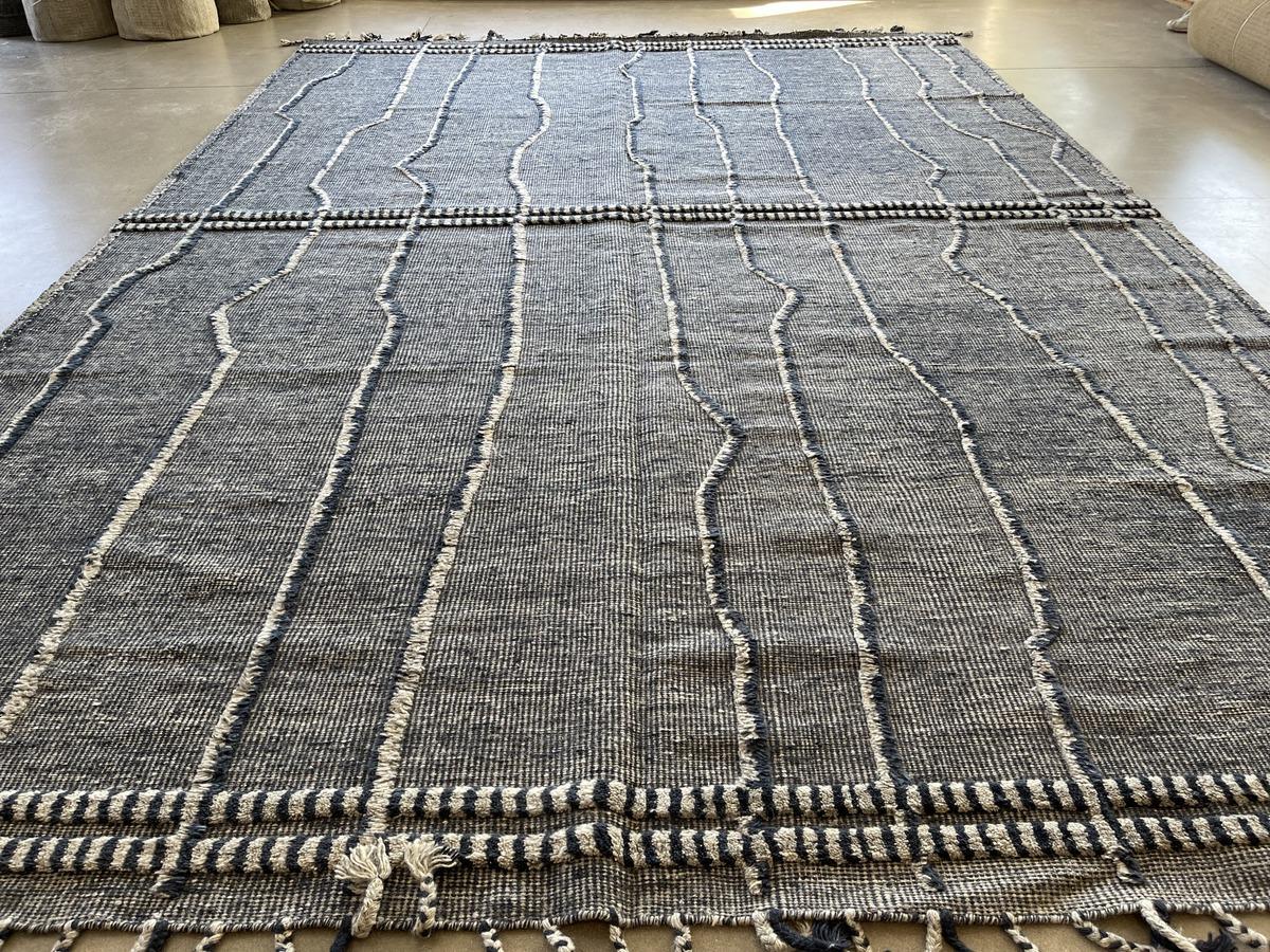 Linien aus geschnittenen Fasern vor einem dicht gewebten Hintergrund sorgen für visuelles Interesse an einem äußerst strapazierfähigen Teppich. Wolle. Hergestellt in Indien mit natürlichen Farbstoffen. Auch in 12 x 15 erhältlich.