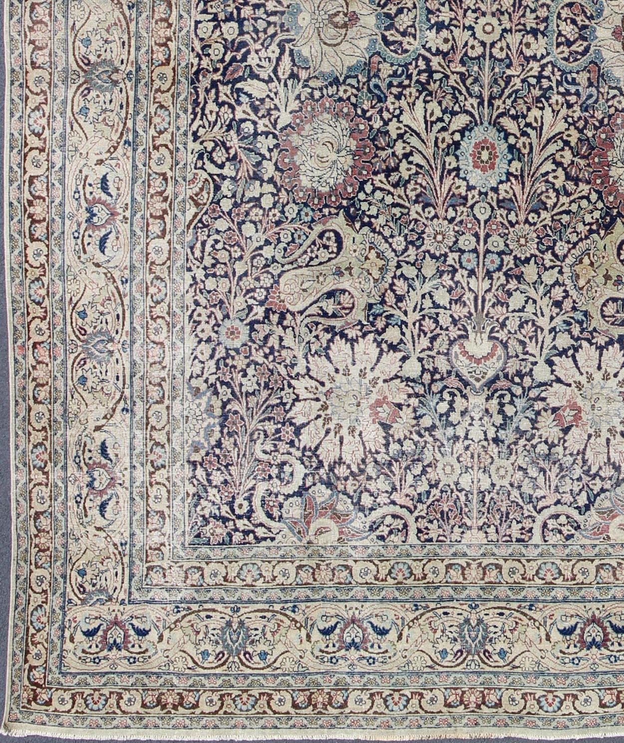 Navy Blue,  ivory and multi colors antique Persian Tabriz rug with all-over large scale floral design, rug zir-5, country of origin / type: Iran / Tabriz, circa 1910

This antique Persian Tabriz carpet (circa early 20th century) features a refined