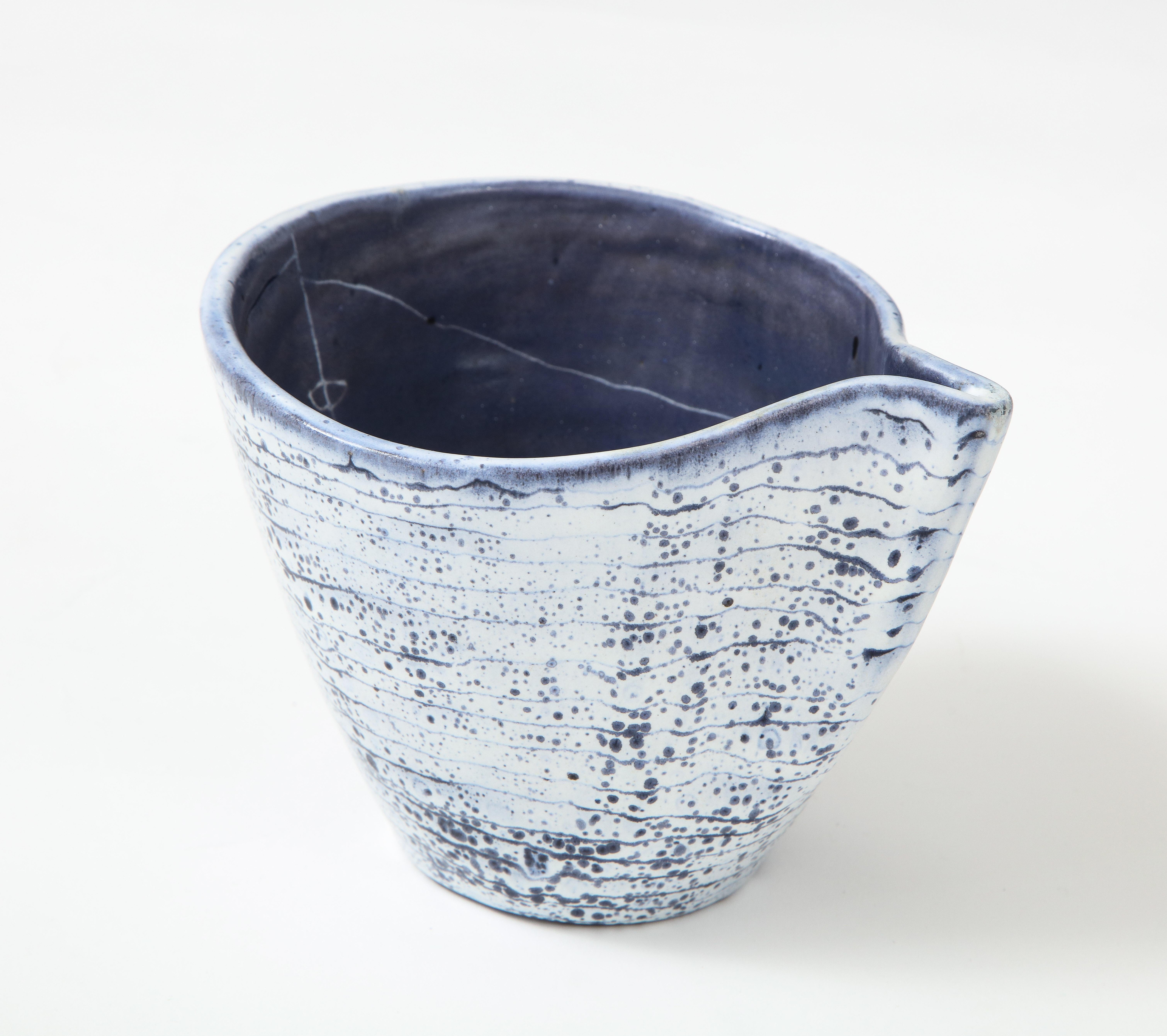 Blue and cream glazed ceramic bowl/vessel by Mado Jolain, France, c. 1955.

This elegant ceramic dish, executed in deep blue and cream tones, displays the signature 