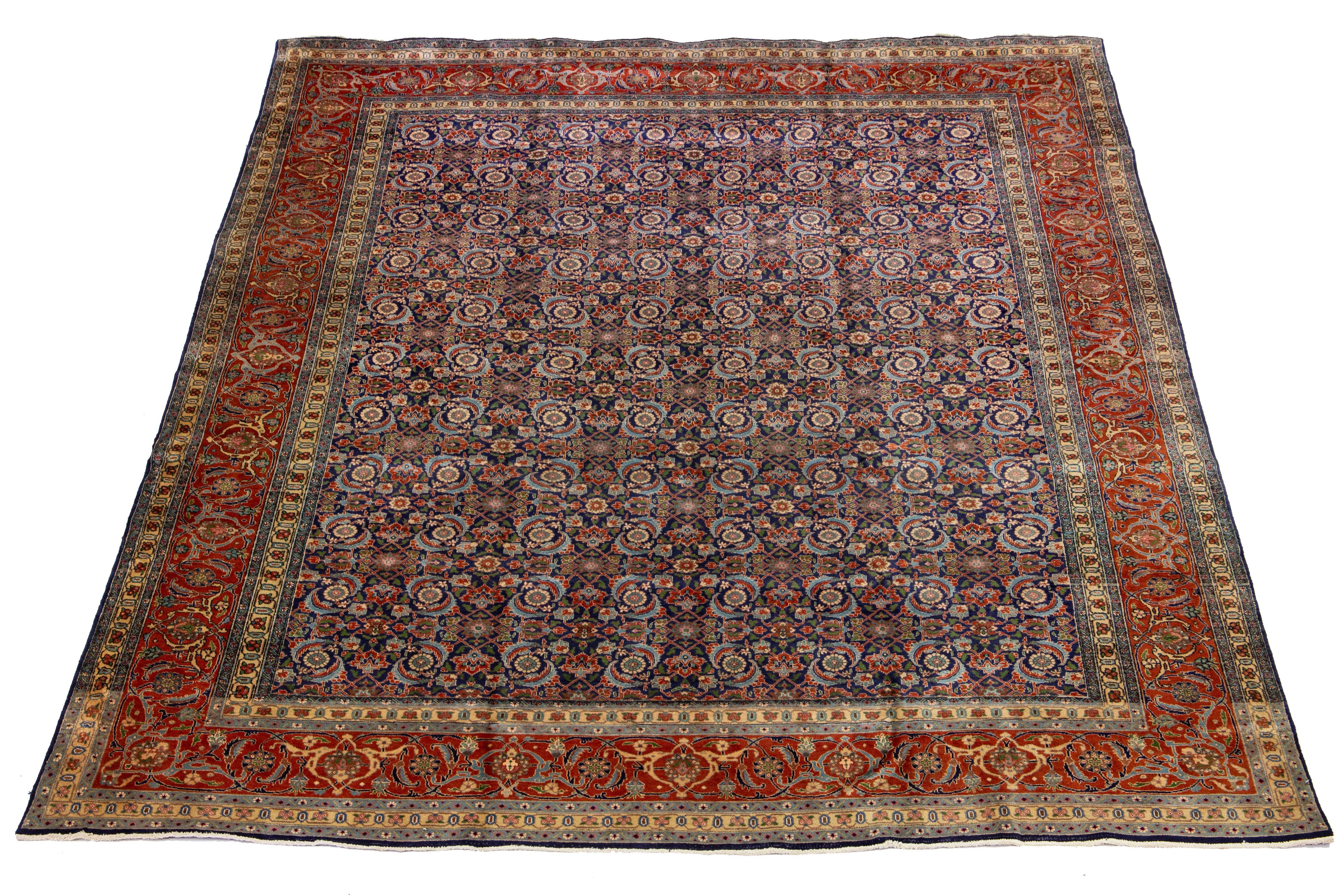 This Persian Tabriz wool rug is beautifully handcrafted and displays a classic all-over floral pattern. The navy blue background provides a contrast that accentuates the design, which features shades of rust-orange, light blue, and green.

This rug
