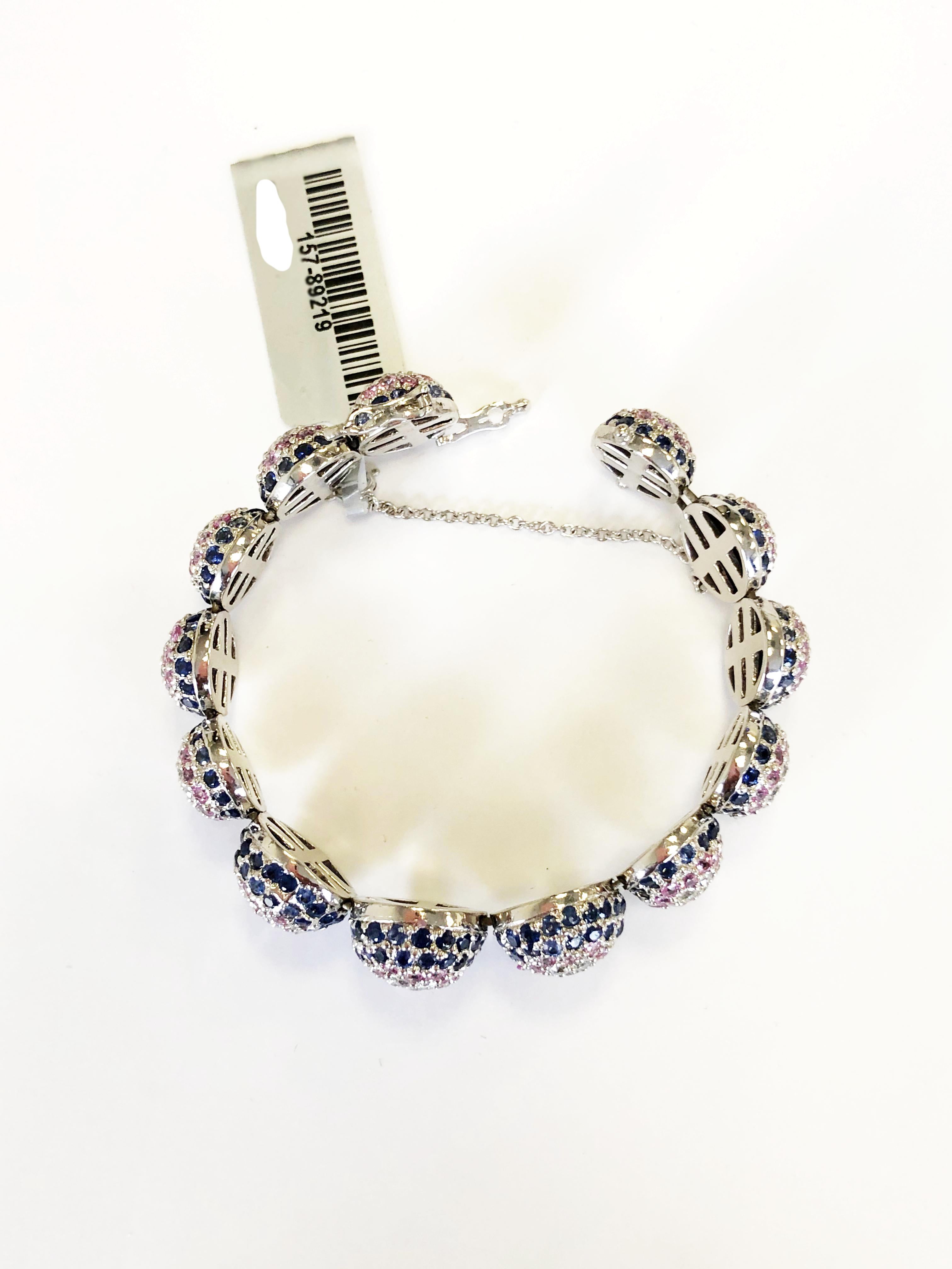 Pave pink and blue sapphire rounds with bright white diamond rounds in this beautiful 18k white gold bangle bracelet.  With a traditional safety chain and clasp, this piece is extra secure without compromising design.  Handmade beautifully.  Great