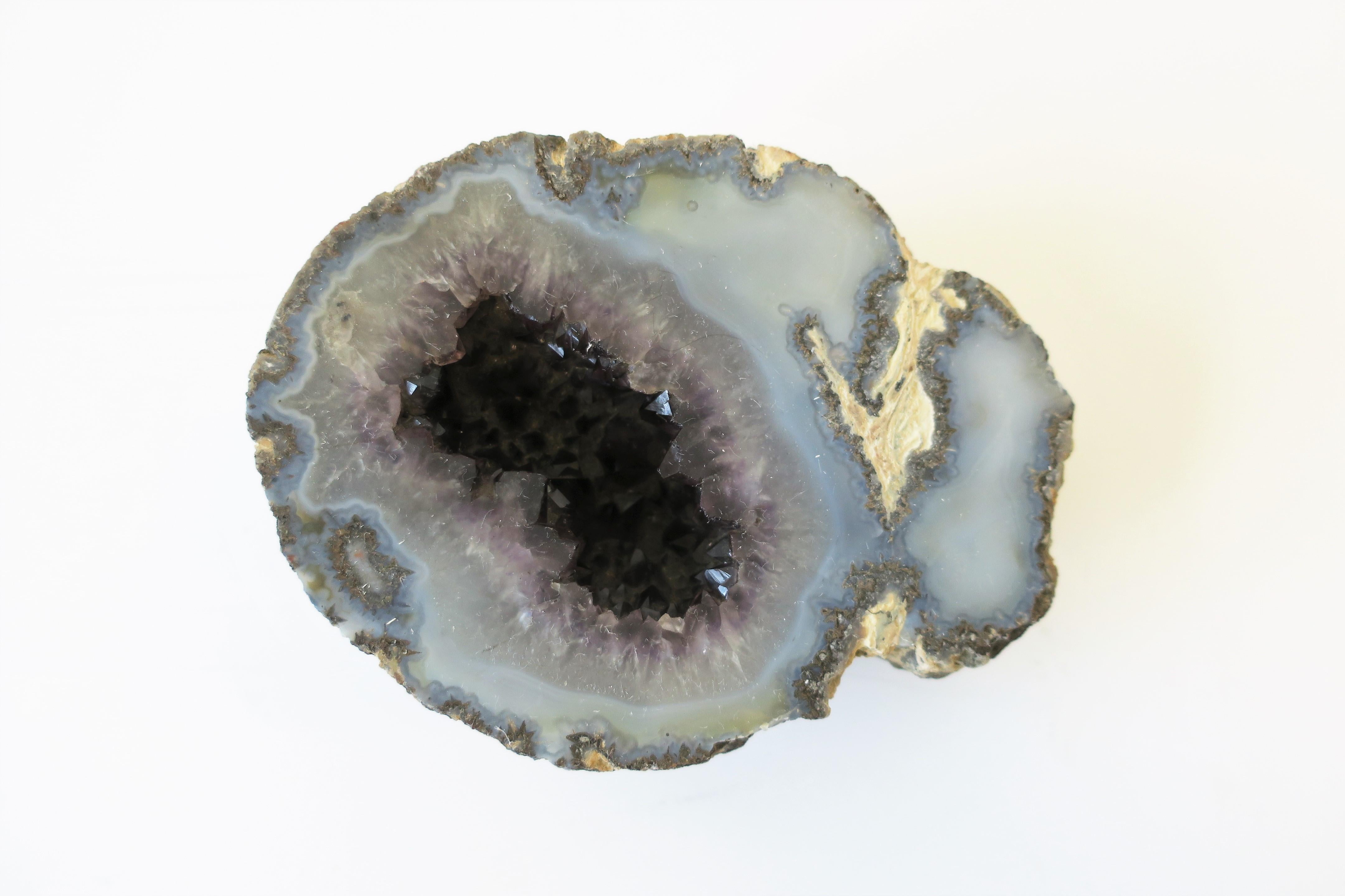 A light blue and purple amethyst geode natural specimen decorative object or paperweight. Piece has a light blue surface with a deep purple amethyst encrusted chasm. Dimensions: 4