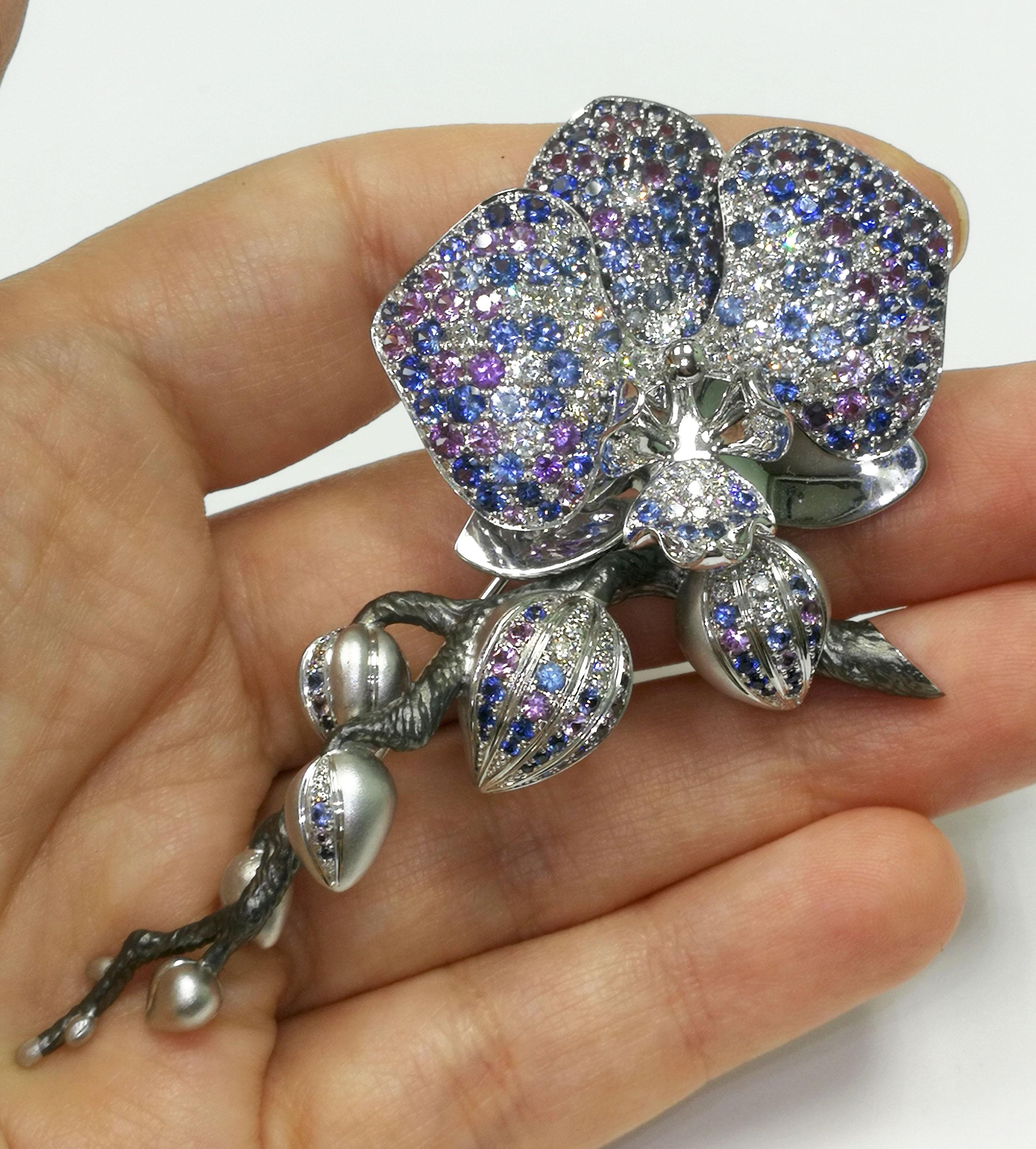 Blue and Purple Sapphires Diamonds 18 Karat White Gold Orchid Brooch
Orchid symbolized at different times a lot of things. Greek women had a theory that they could manipulate the sex of their unborn baby with the roots of an orchid. The Aztecs were