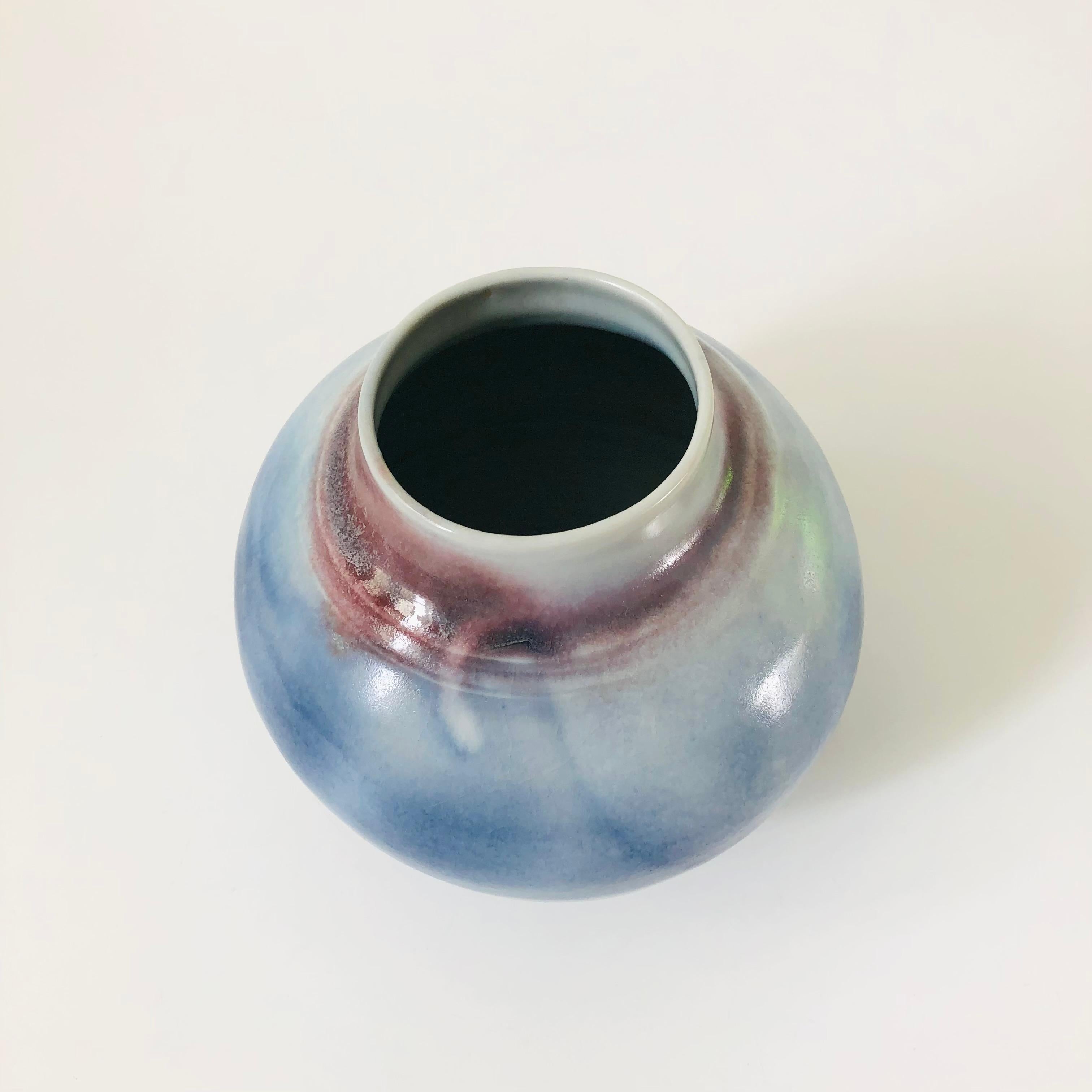 A vintage studio pottery vase. Beautiful variation in the blue and purple glazes. Nice round tapered shape. Signed 