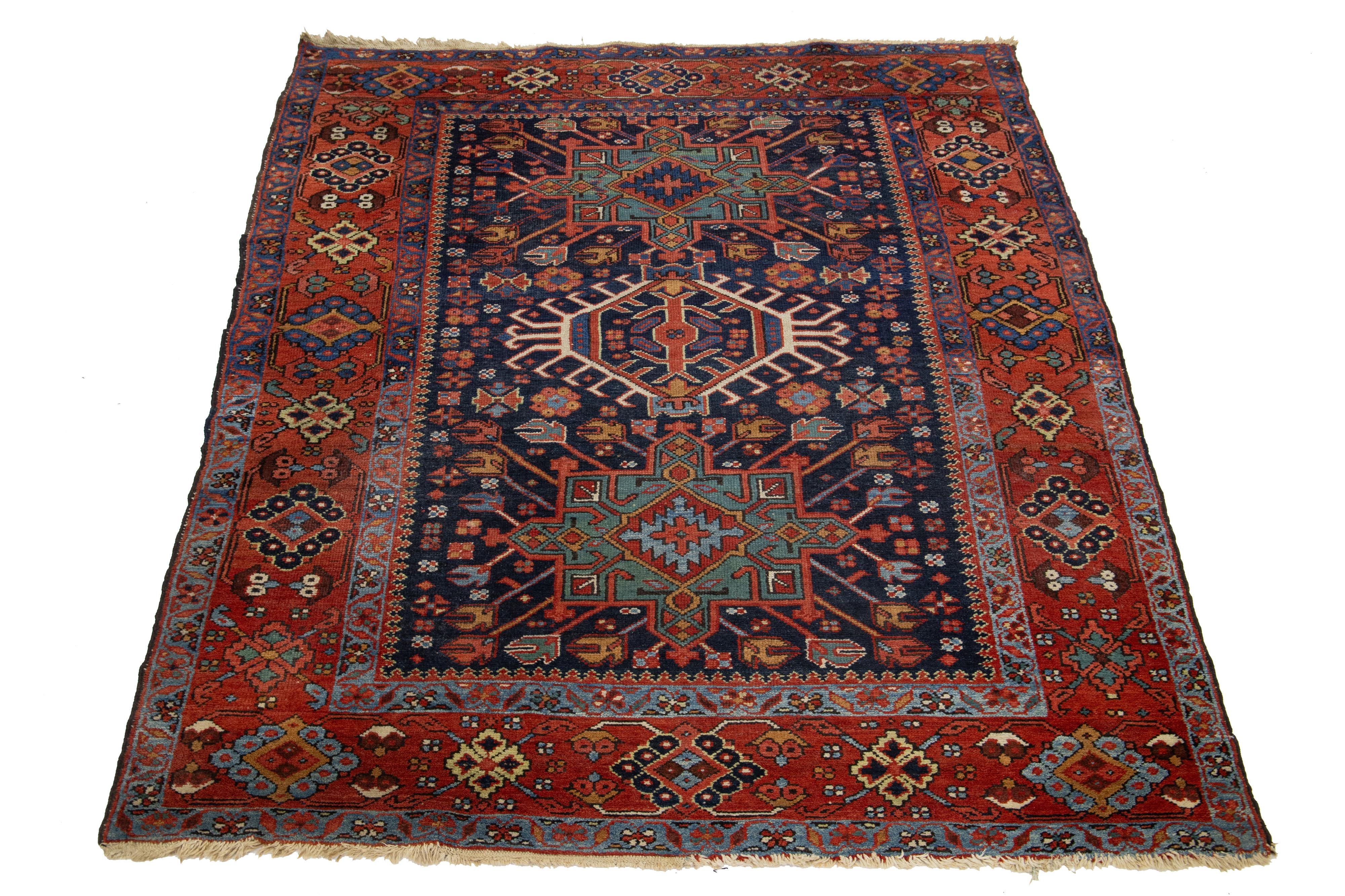 Questo bellissimo tappeto vintage in lana annodato a mano di Karajah presenta un campo blu navy con accenti multicolore in uno splendido disegno geometrico a medaglione all-over.

Questo tappeto misura 5' x 6' 6