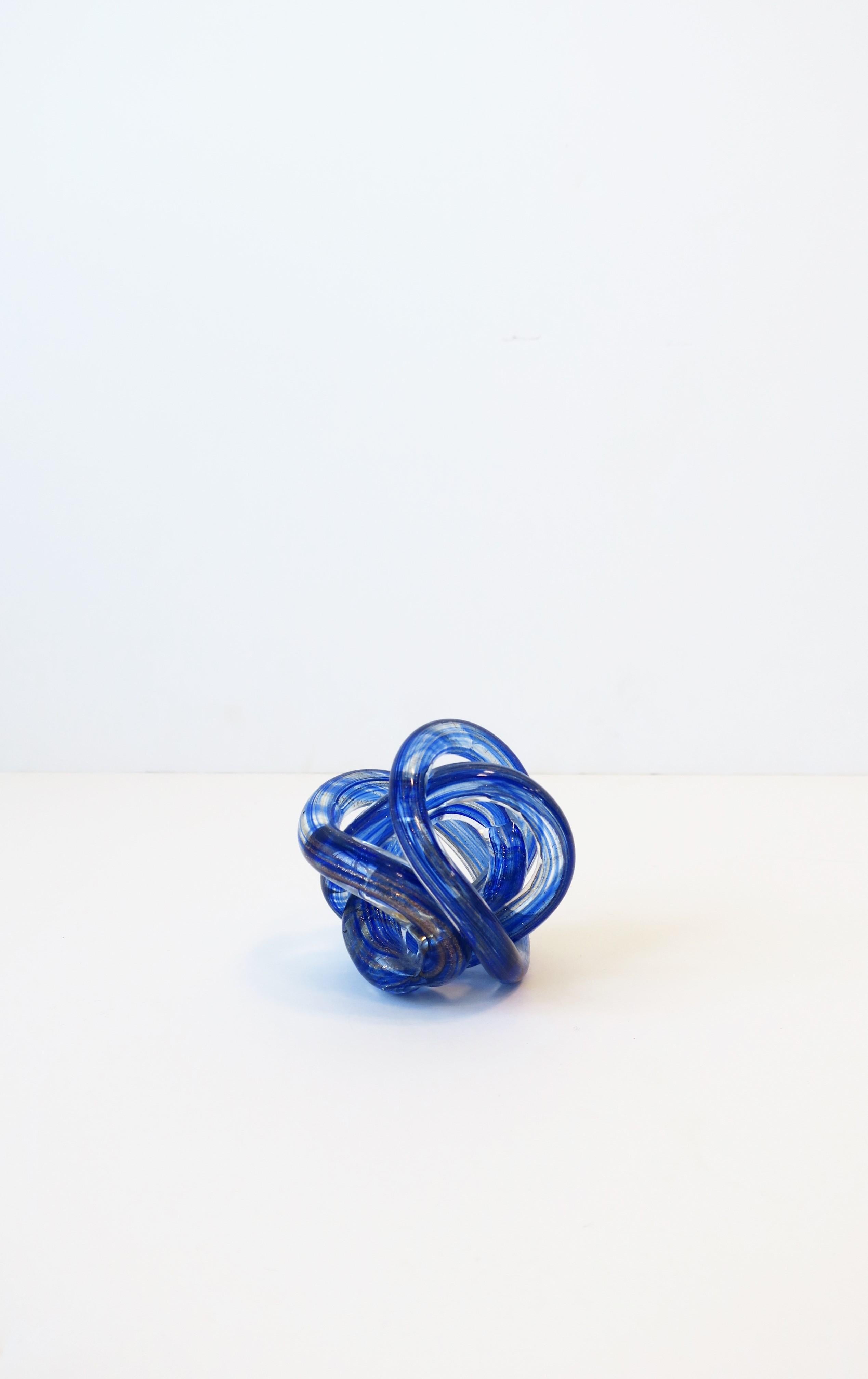 A beautiful blue, shimmering copper, and clear art glass knot decorative object. A chic piece for a desk, shelf, etc.

Piece measures: 2.75