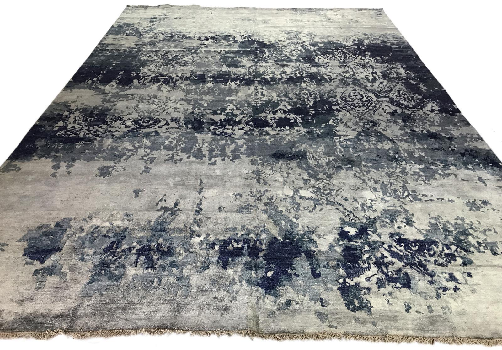 Cool blue and silver tones create a very contemporary look that reveals itself in subtly different ways with each angle of view. The high low styling adds texture as an additional element of excitement for a space. Wool. Hand knotted in India.