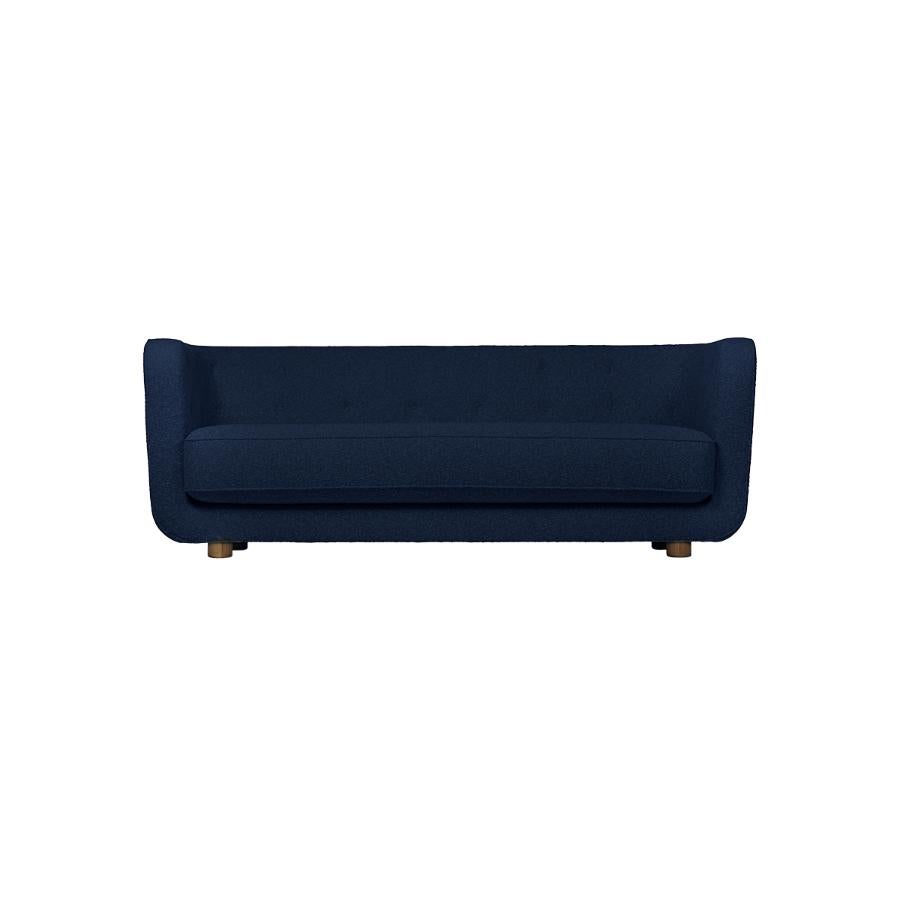 Blue and smoked oak Hallingdal Vilhelm sofa by Lassen.
Dimensions: W 217 x D 88 x H 80 cm.
Materials: textile, oak.

Vilhelm is a beautiful padded 3-seater sofa designed by Flemming Lassen in 1935. A sofa must be able to function in several