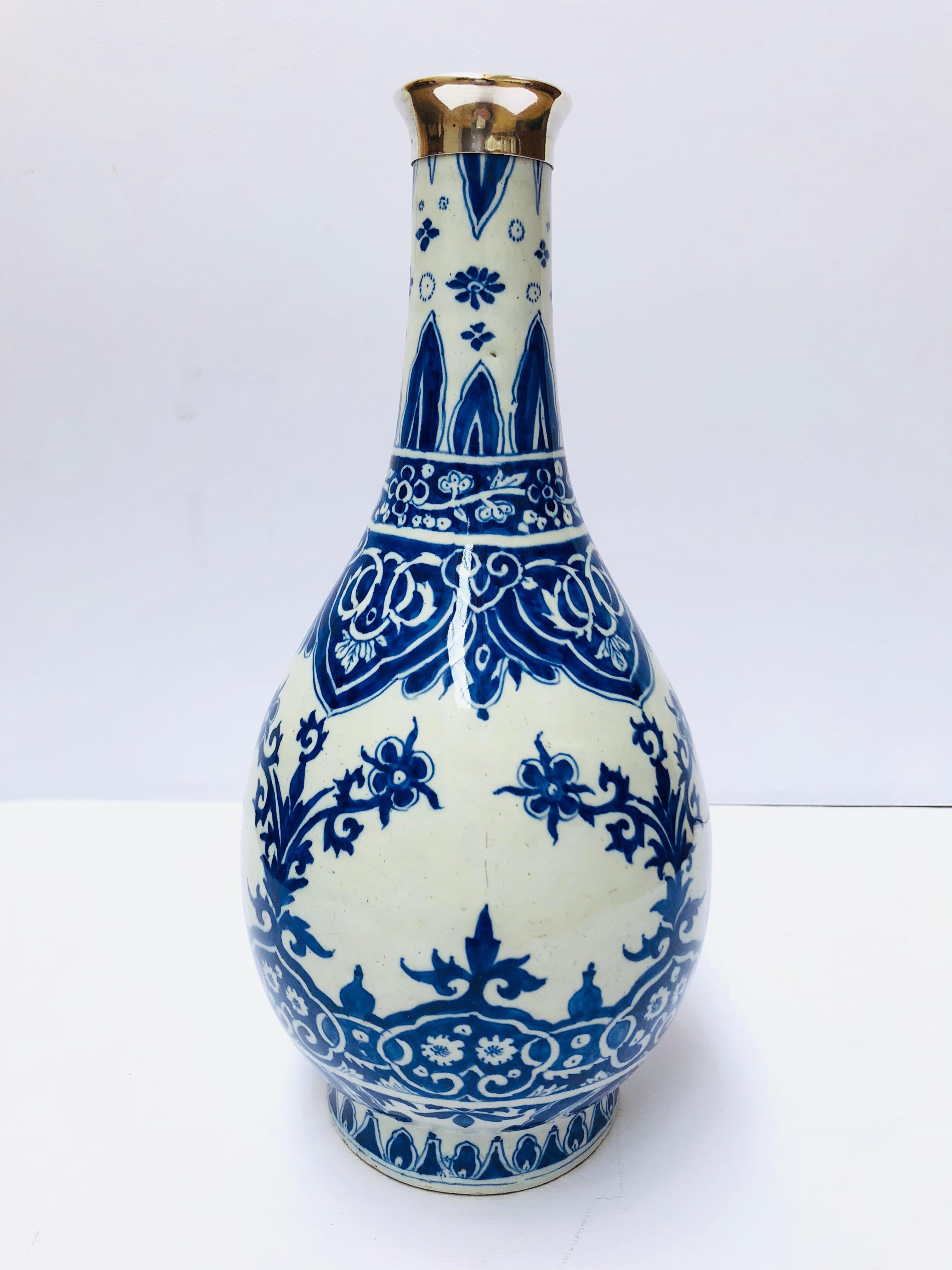 Marked AK no 10 for Adrianus Kocx , the owner of factory De Griekse A from 1686-1701
Pear-shaped body, gradually marging into a high cylindrical neck; painted in under glaze blue with various bands of flowers and scrolling foliage and lambrequins,