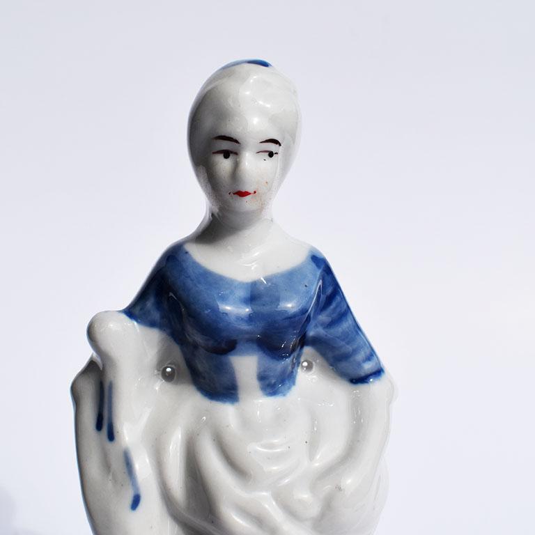 Ceramic figurine of a woman in blue and white glaze. For grand millennials and chintz lovers, this small porcelain figurine will make a superb addition to your blue and white collection. This lovely piece depicts a peasant woman carrying her wares.
