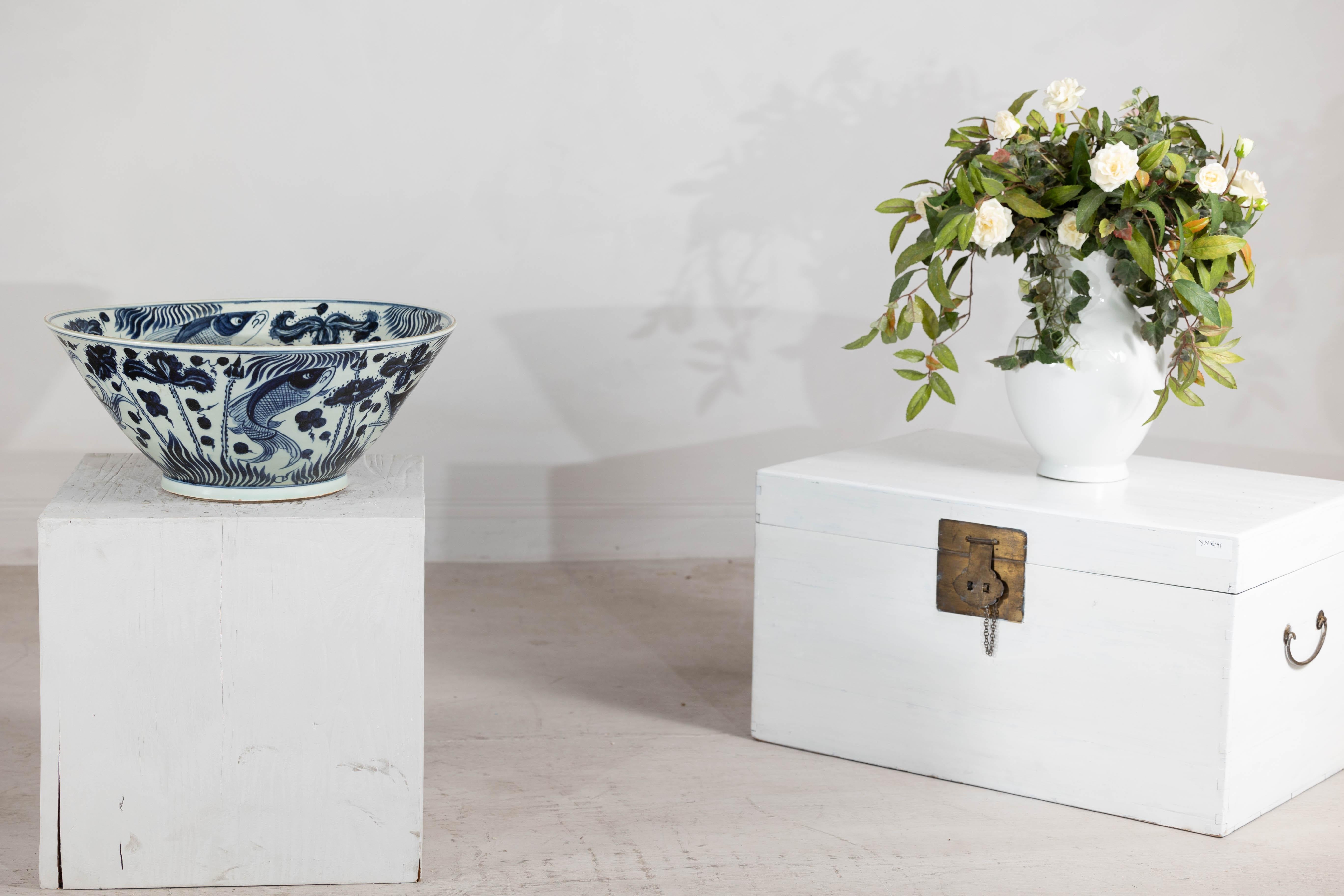 Este cuenco de porcelana china, adornado con intrincados motivos bajo vidriado pintados a mano, muestra una intemporal paleta azul y blanca. Probablemente de mediados del siglo XX, pero inspirado en los estilos tradicionales de las dinastías Ming y
