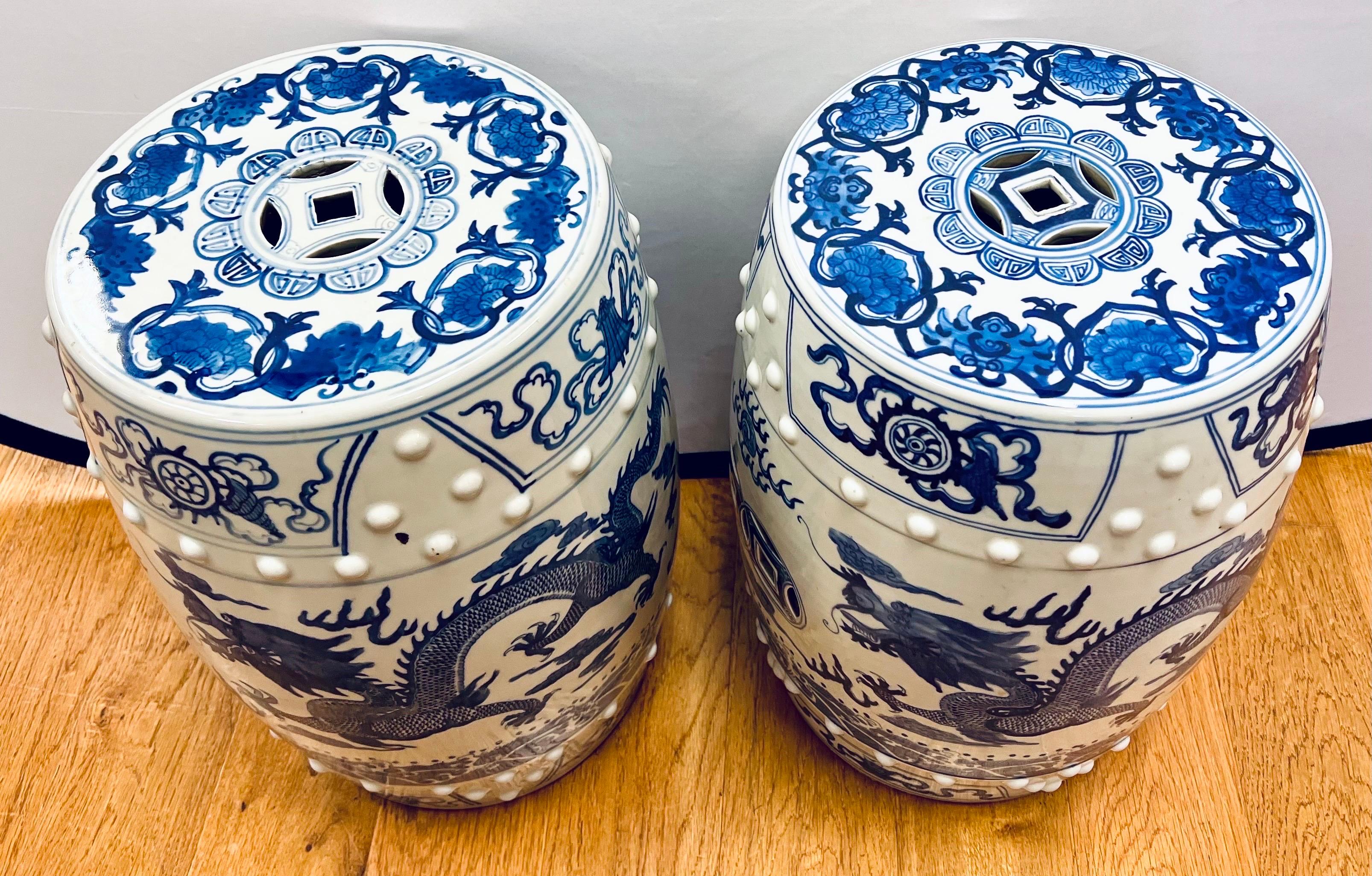 Stunning pair of Chinese blue and white porcelain garden stools with intricate hand painted motif of dragons, fish and flowers.  Pierced detail at top and sides.  Each piece is incised with artist's number.  Can also be used as side or drink tables.