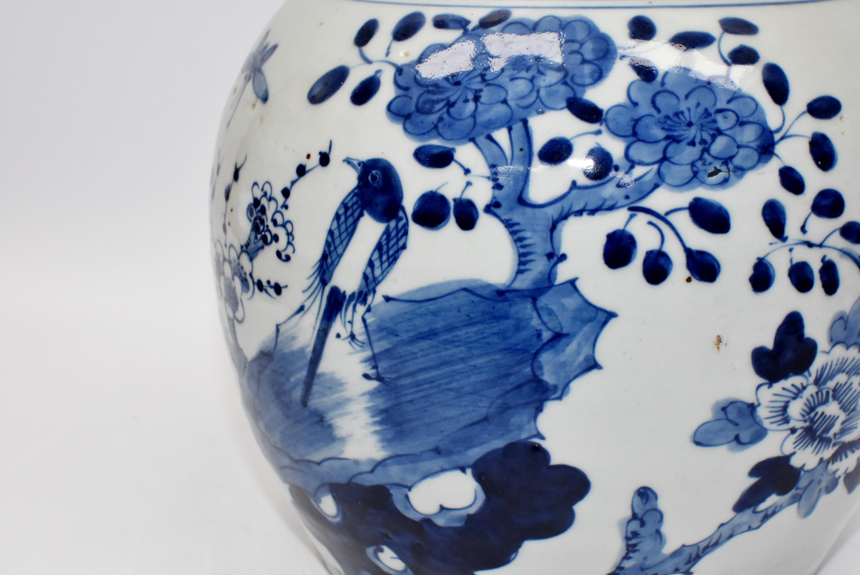 A beautiful 20th century Chinese blue and white ginger jar depicting a magpie resting on the rock under a plum blossom tree with a butterfly in the sky and peonies blooming. A ring of eternity scrolls decorate the area near the opening. Images are