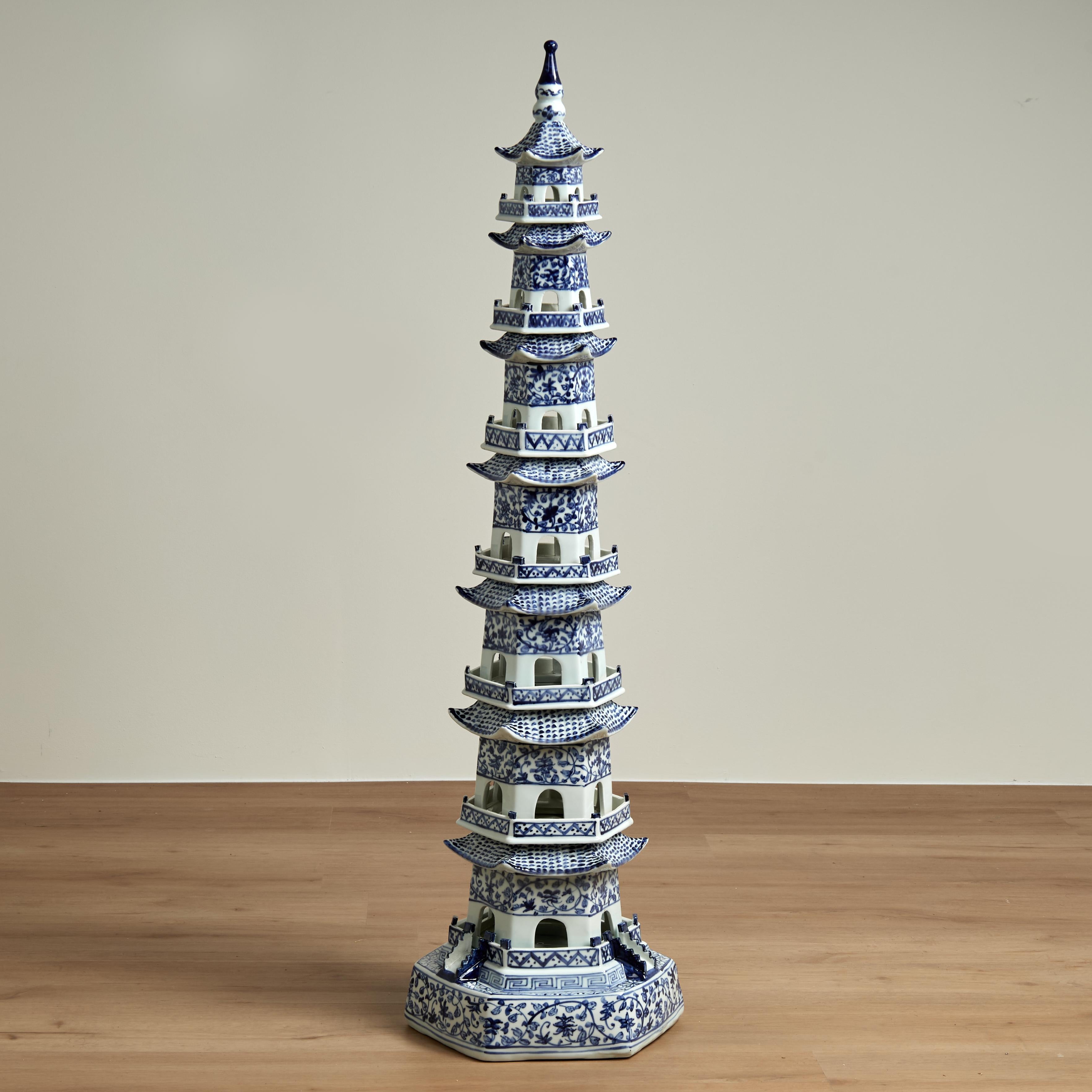 Elevada torre de porcelana china azul y blanca fabricada en siete piezas apilables en dramática forma de pagoda y decorada a mano con diseños florales y geométricos.