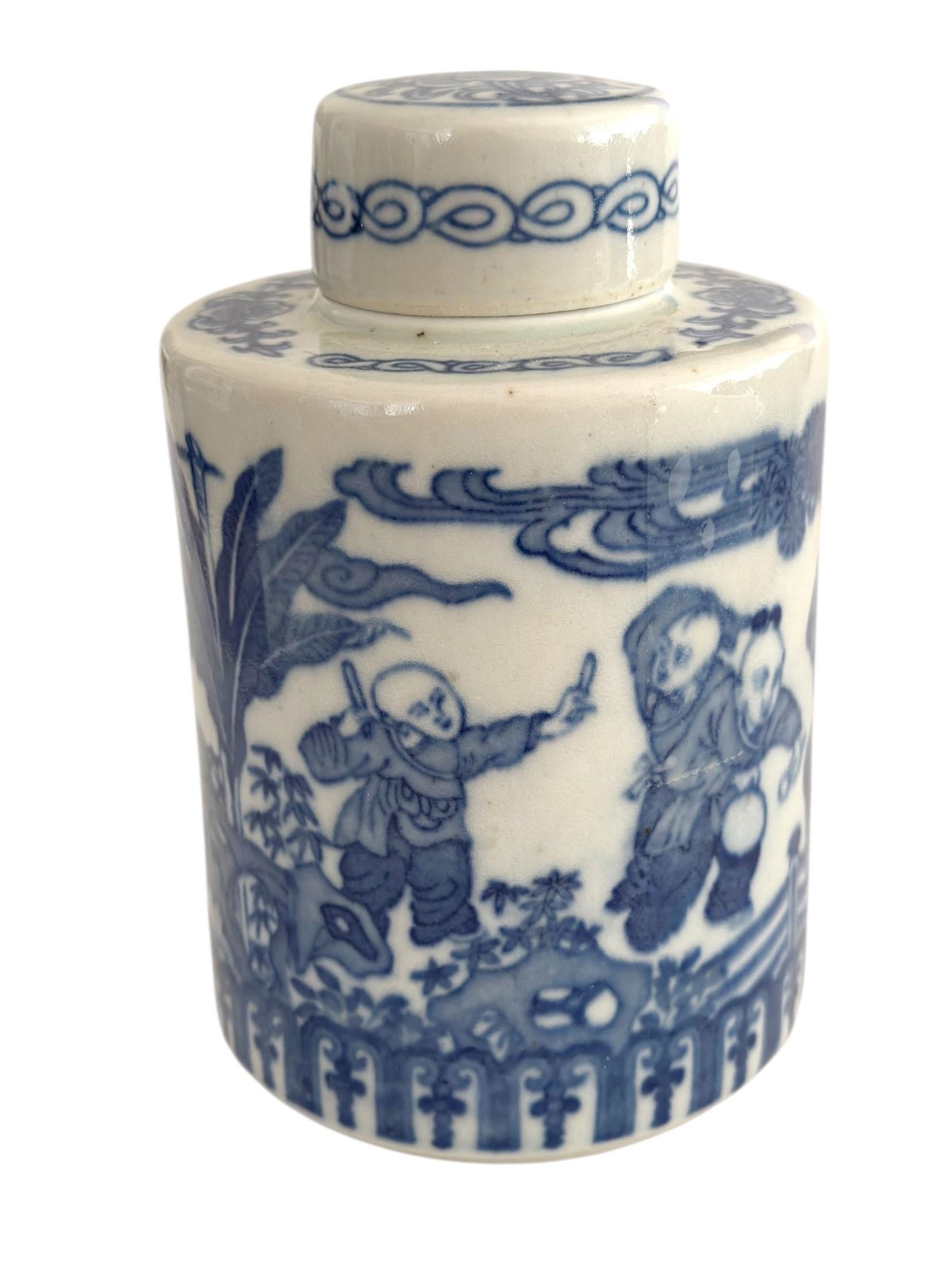 A cylindrical blue and white porcelain tea caddy, finely decorated with the traditional “boys at play” motif symbolizing prosperity, fertility, and family harmony in Chinese art. The scene shows children playing among rocks and garden landscapes,