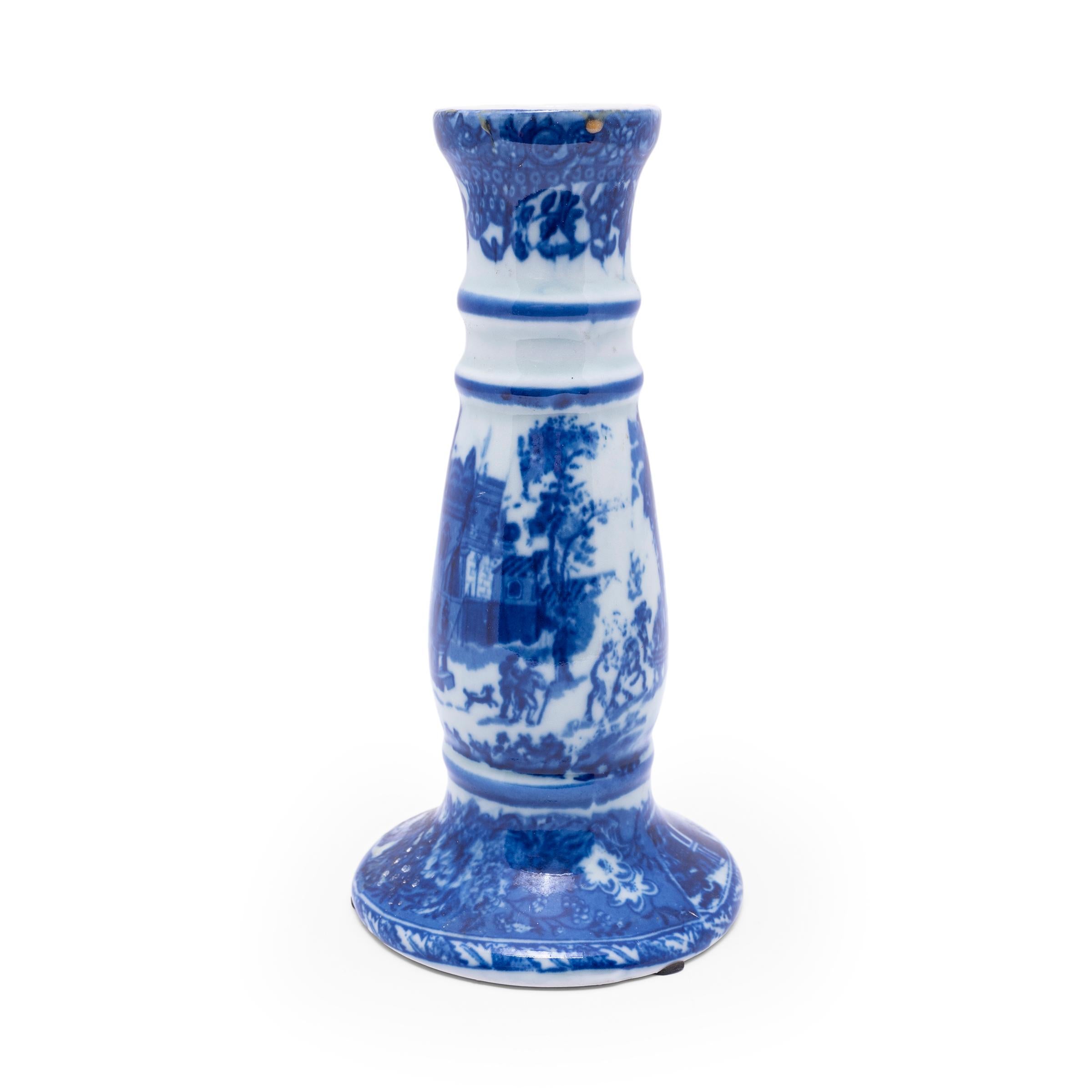 Ce vase vintage en porcelaine a la forme d'un grand bougeoir et est décoré d'un motif de Chinoiserie bleu et blanc représentant un paysage idyllique sur la place d'une ville. Le design de la vaisselle à transfert recrée la vaisselle en pierre de fer