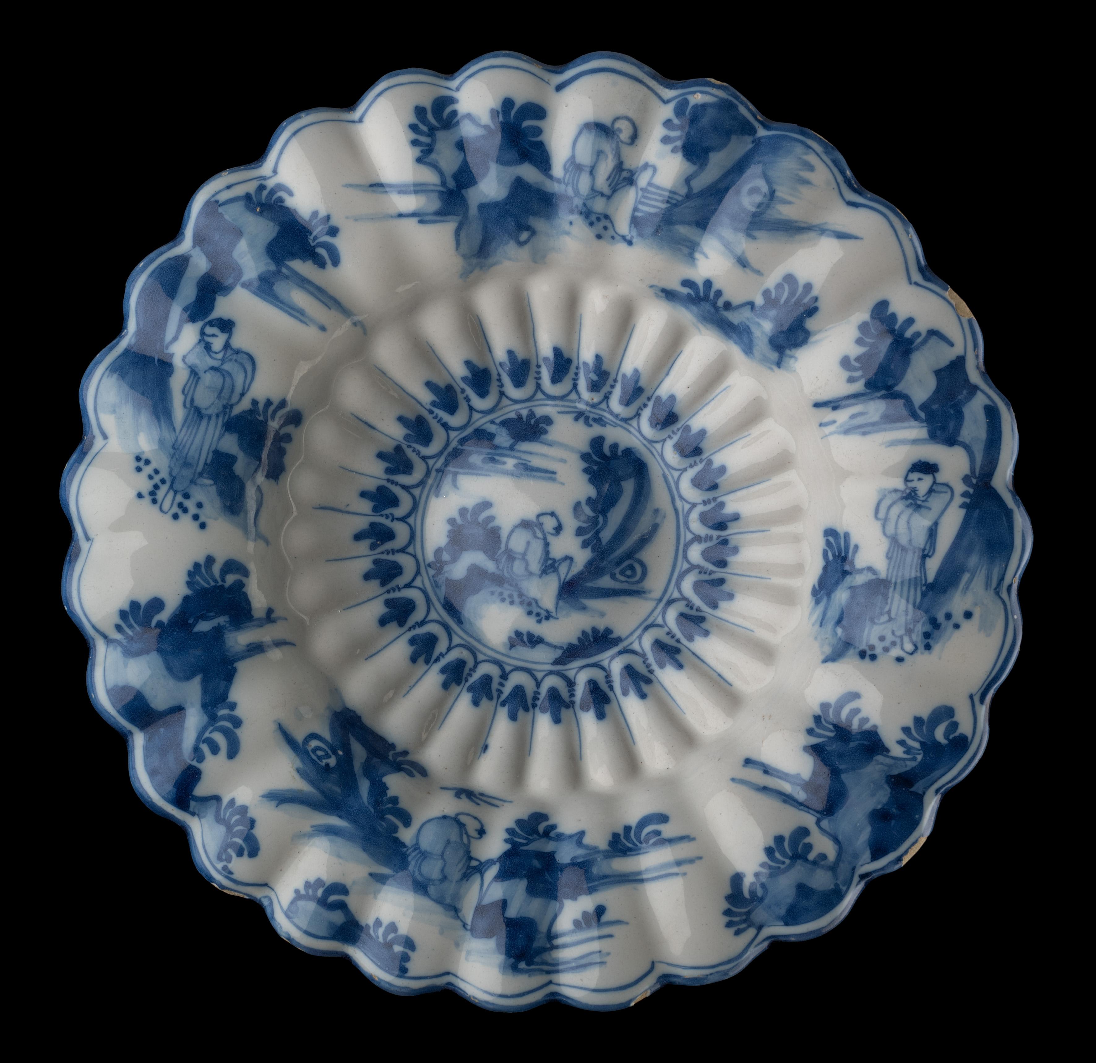 Blue and white chinoiserie lobed dish. Delft, 1650-1680 
Dimensions: diameter 33,5 cm / 13.18 in. 

The blue and white lobed dish is composed of twenty-seven double lobes. The curved center is painted with a Chinese in an Oriental landscape,