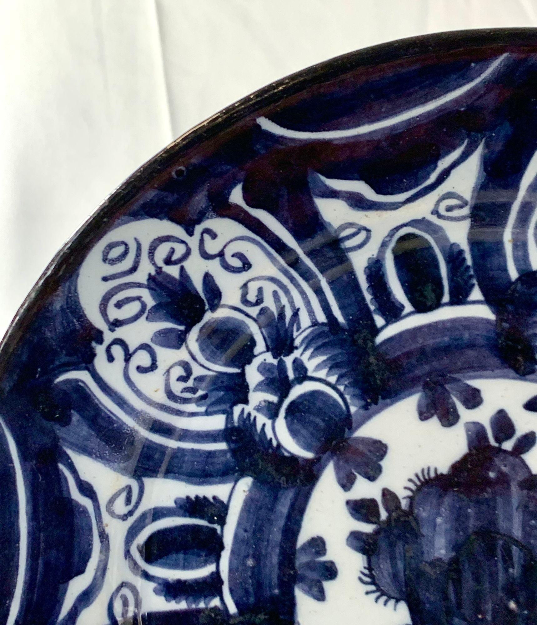 Ce ravissant chargeur Delft hollandais du XVIIIe siècle présente une décoration peinte à la main dans un bleu foncé profond.
Nous voyons dix panneaux de décoration florale remplis de bulbes de tulipes et de vignes enroulées.
Dimensions : 11,5