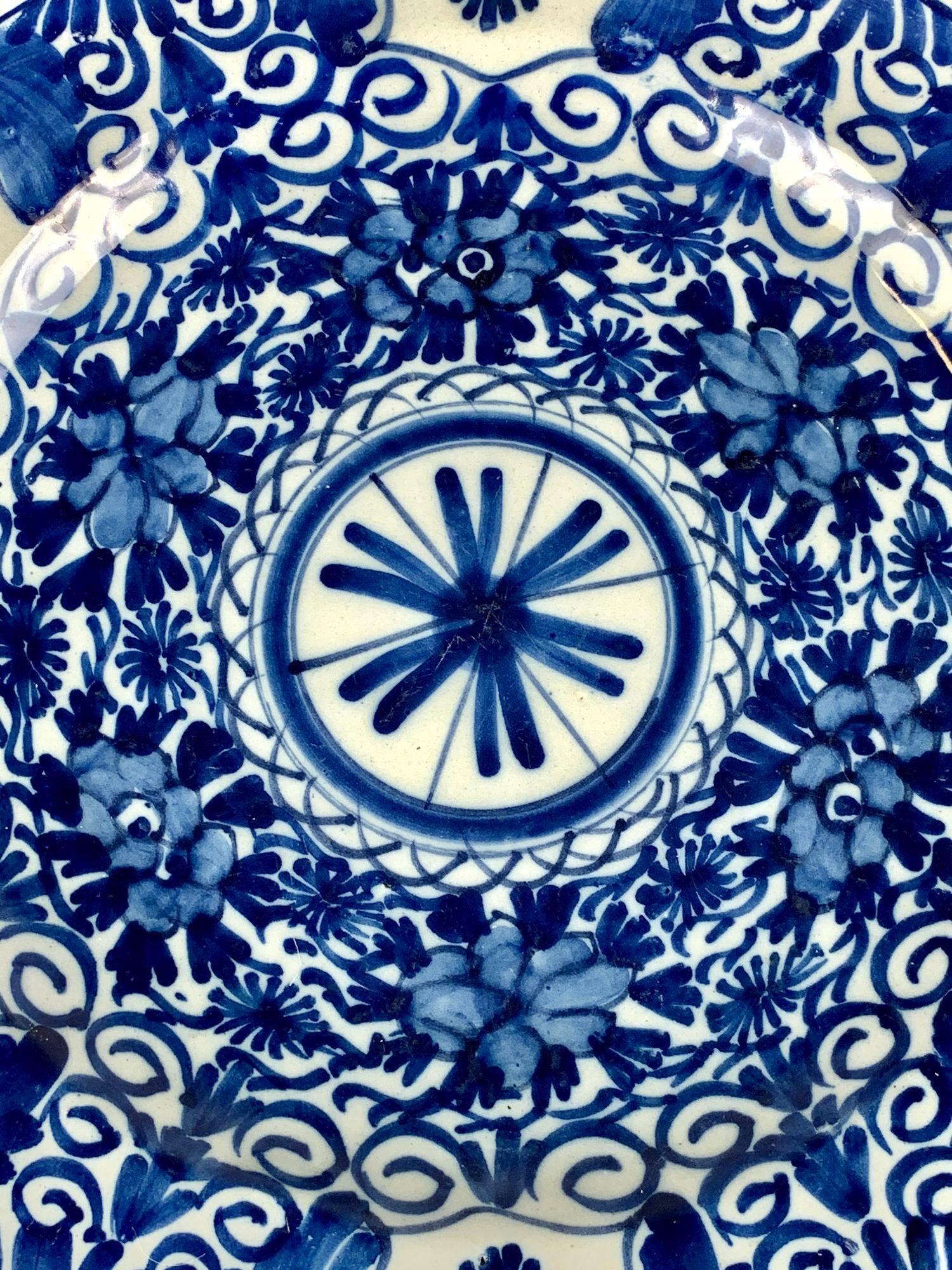 This beautiful blue and white hand painted charger was made in The Netherlands in the last quarter of the 18th century, circa 1780.
It is decorated with an eye-catching floral design that encircles a central medallion.
We see floral bands showing