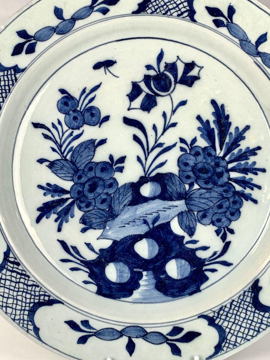 This beautiful blue and white Dutch Delft charger shows a vibrant and detailed garden scene hand-painted in shades of cobalt blue.
The decoration is crisp. 
The artist gave life to the well-painted scene by using a variety of shades of blue.
Flowers
