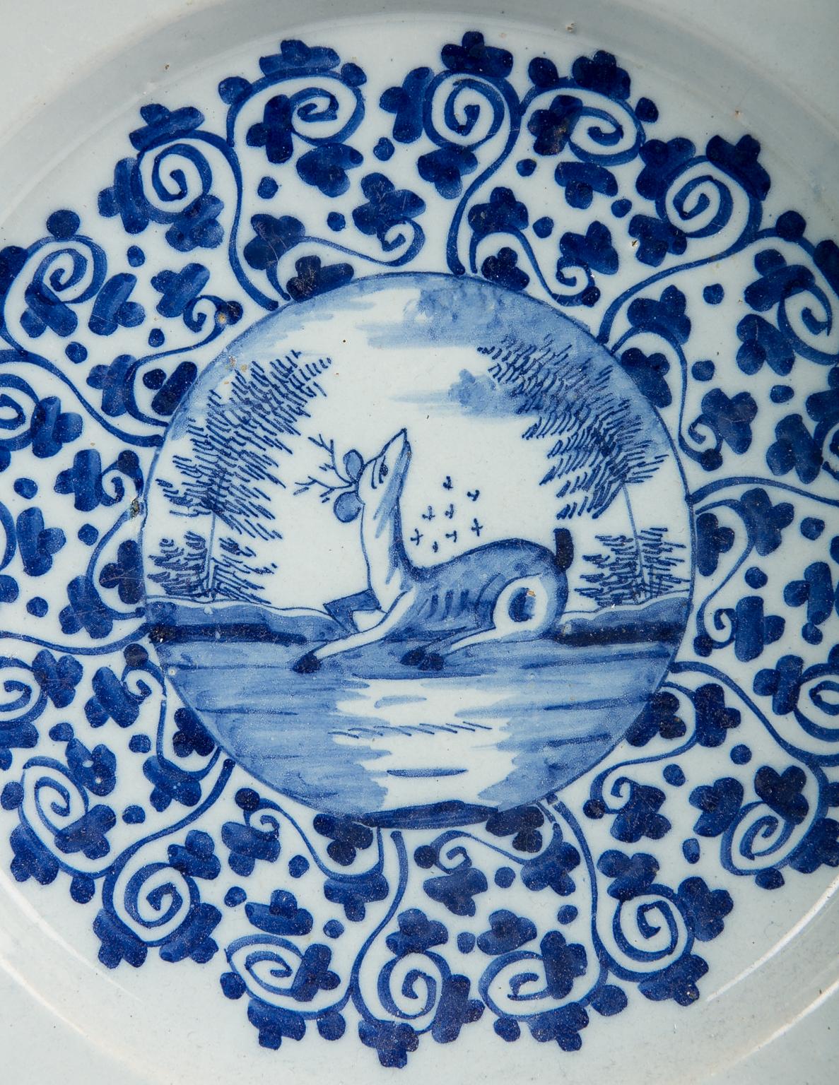 An exquisite blue and white Dutch Delft charger showing a deer in a clearing in the forest. The deer is painted in a roundel at the centre of the charger. Around it are two circles of scrolling leaves. The overall effect is beautiful.
Dimensions: