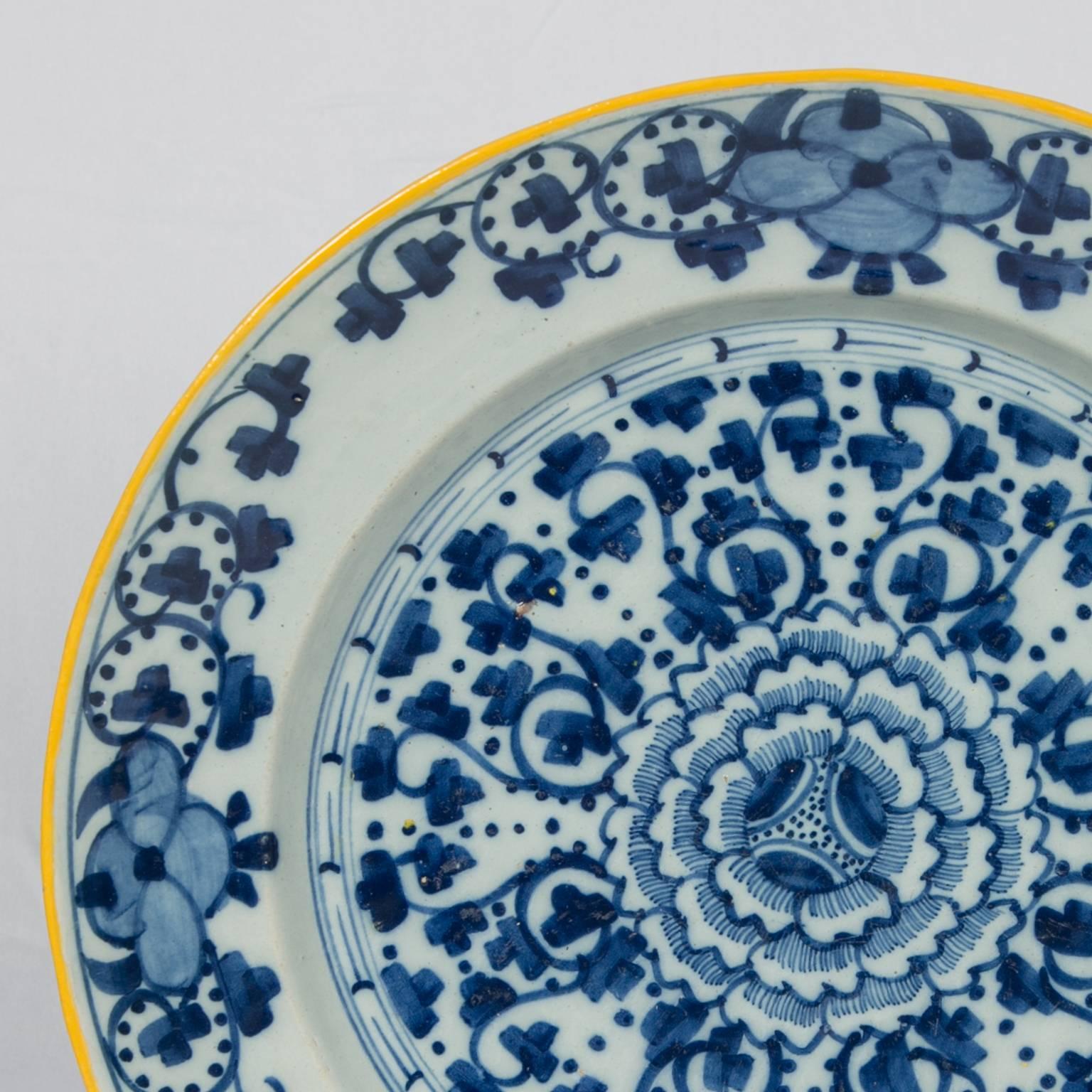 We are pleased to offer this exceptional blue and white Dutch Delft charger painted in bright cobalt blue with a large peony in the center. Scrolling vines and flower heads radiate from the peony in a crisp, geometric pattern. The charger has a