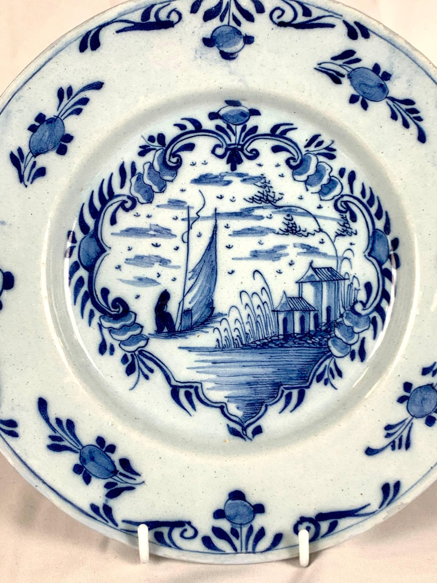 This hand painted blue and white dish was made in Delft, The Netherlands, circa 1770.
The center scene is painted within a decorative cartouche.
We see a fisherman on a sailboat moving away from the viewer and out to sea.
The wide border is
