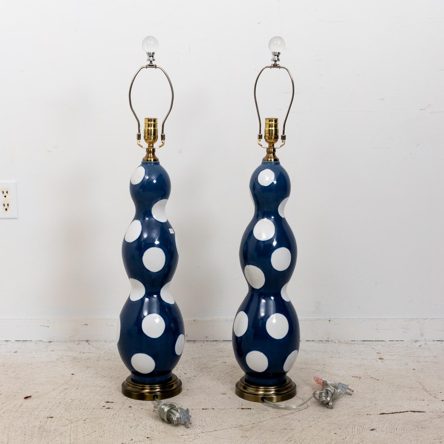 Blue painted table lamps in the Mid-Century Modern style decorated with white dots in a glazed finish. Please note of wear consistent with age. Shades not included.