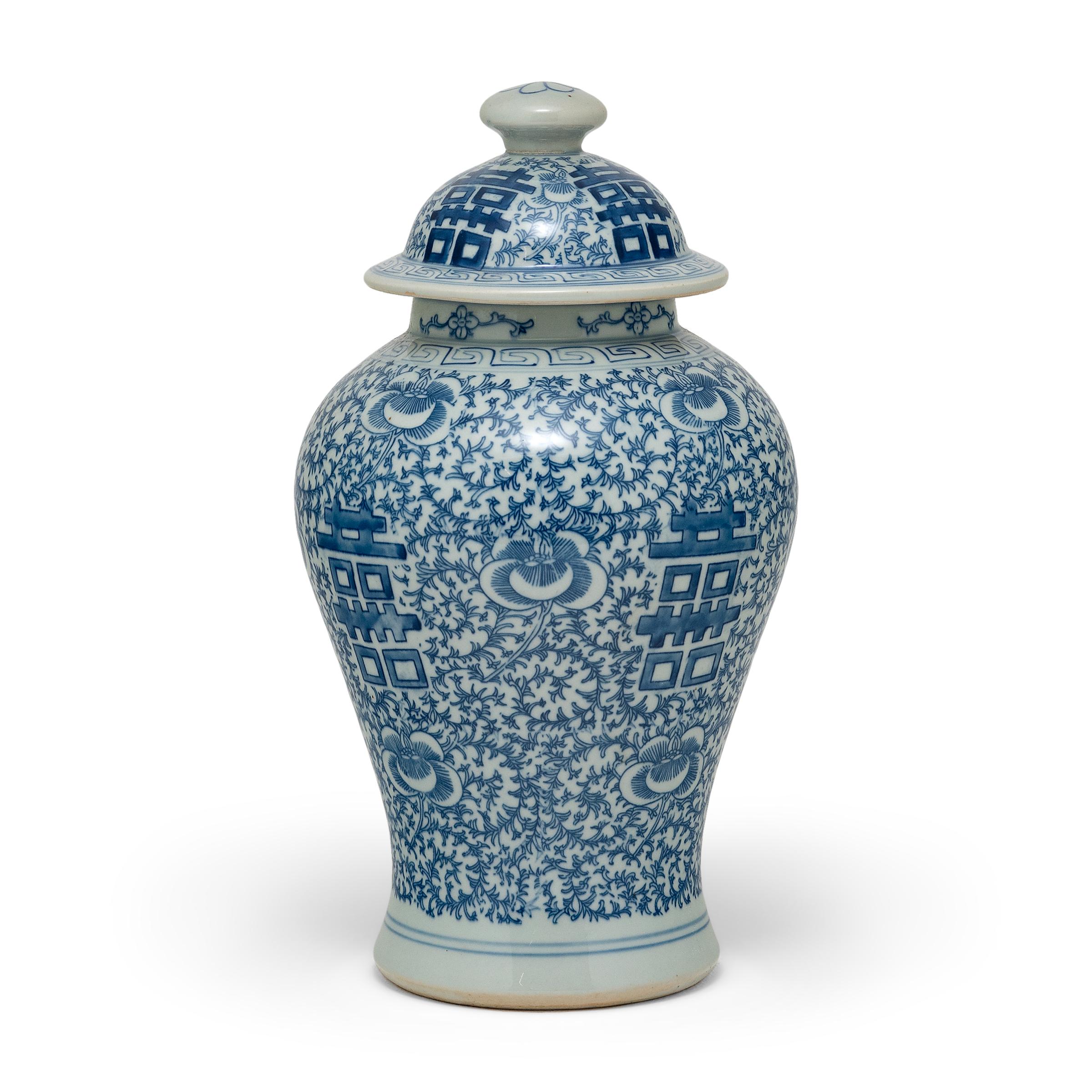 The symbol for double happiness adorns this slender ginger jar with best wishes for love, companionship and marital bliss. Glazed in the classic blue and white manner, the porcelain ginger jar has a classic form with rounded shoulders that taper to