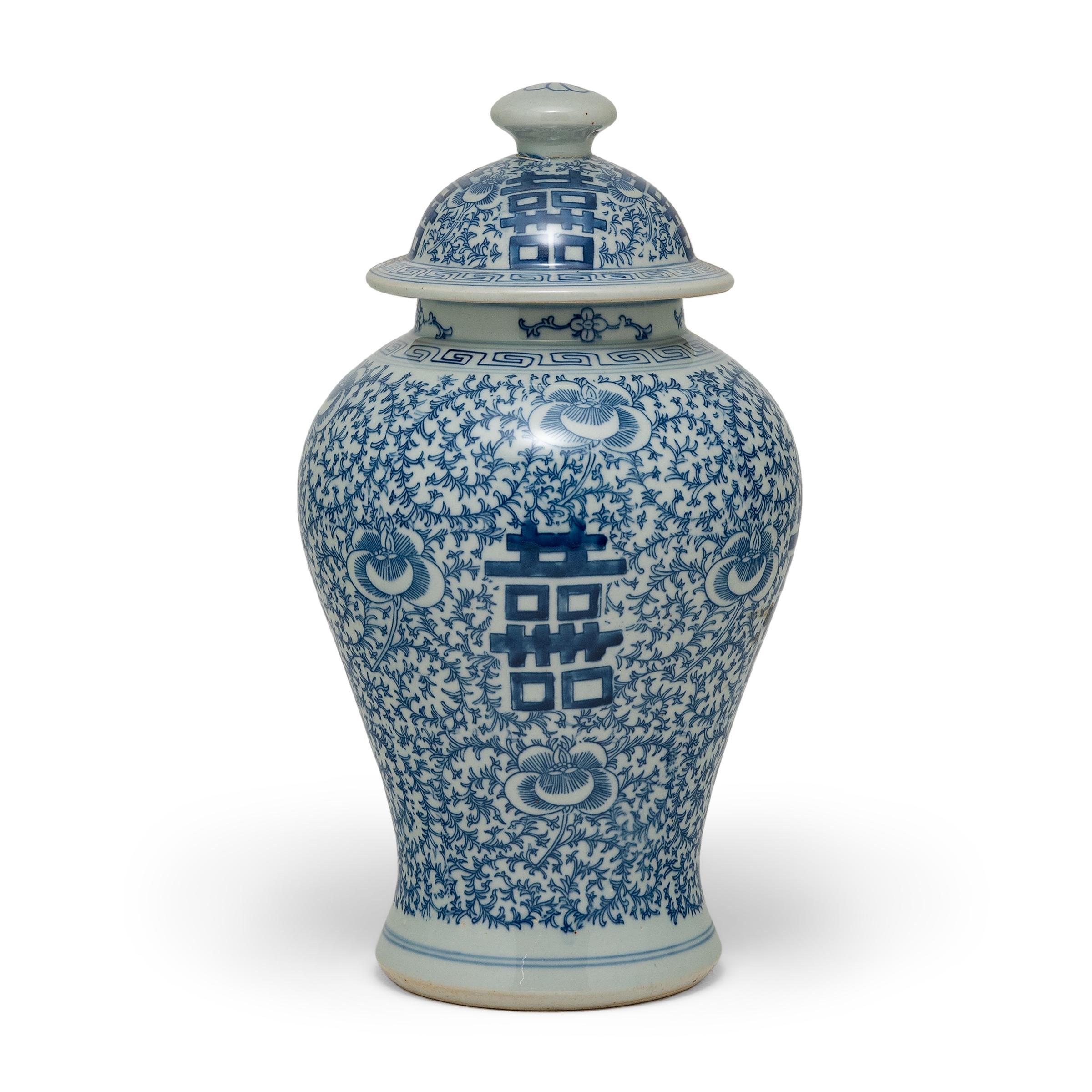 The symbol for double happiness adorns this slender ginger jar with best wishes for love, companionship and marital bliss. Glazed in the classic blue and white manner, the porcelain ginger jar has a classic form with rounded shoulders that taper to