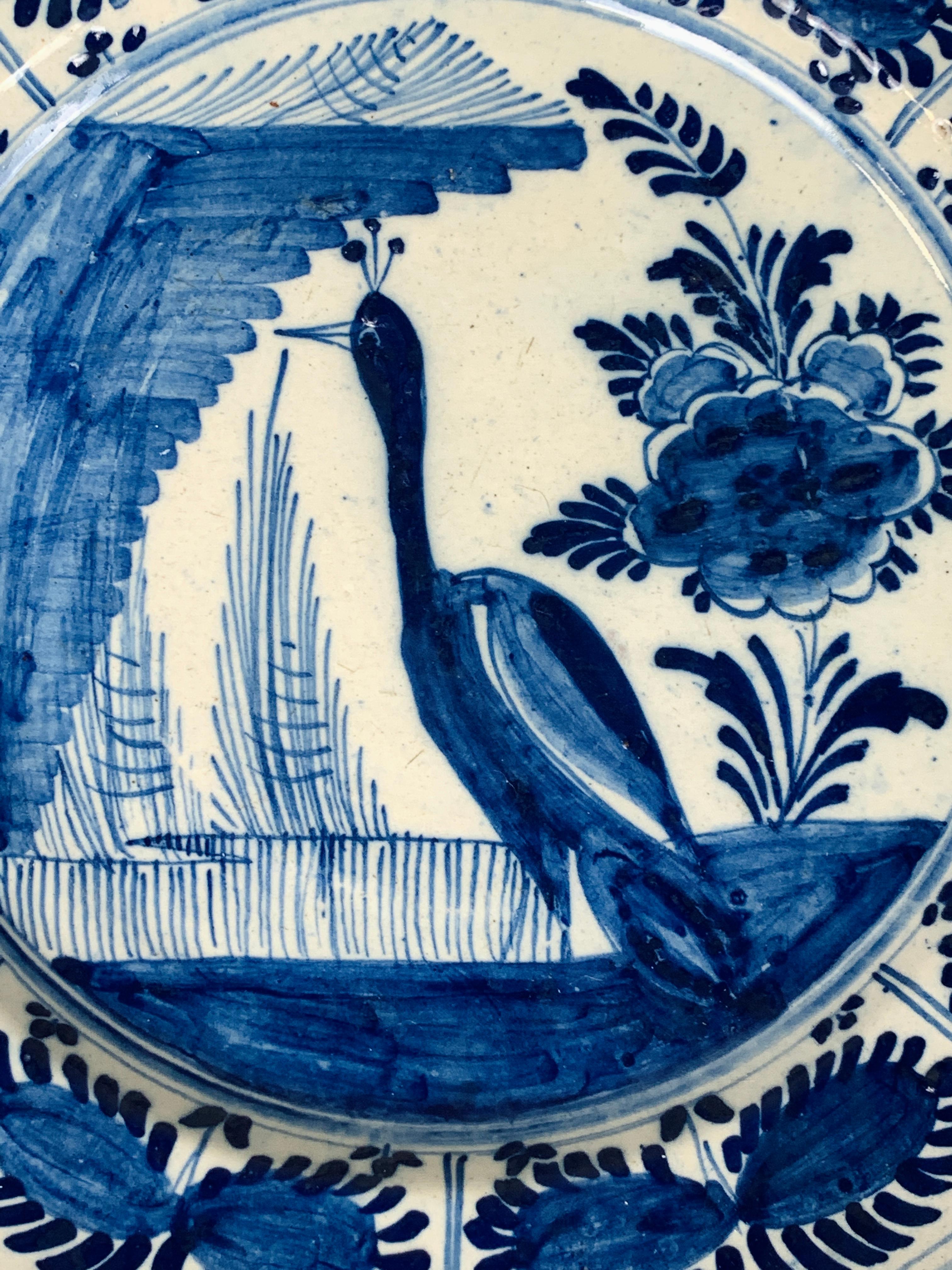 This blue and white delft charger is hand-painted in cobalt blue. We see a peacock standing at the edge of a pond, and next to it is an oversized peony. But, it is the majestic bird that captures our eye.
Dimensions: 12.25
