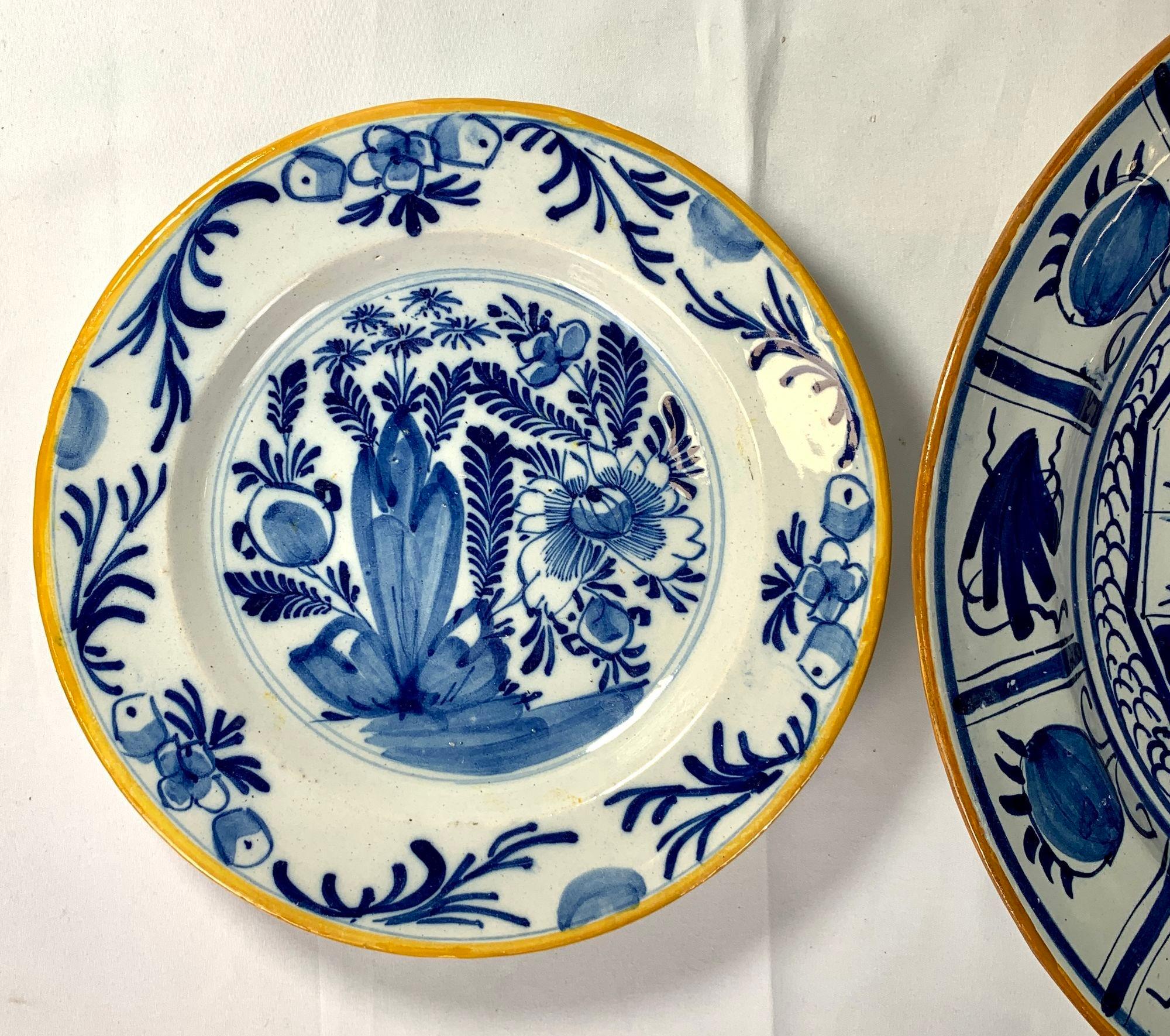 This lovely group of hand painted blue and white Dutch Delft plates features scenes traditional to 18th century Delft.
Each plate is painted in cobalt blue with a traditional yellow or ochre painted edge.
In the group's center, we see a large