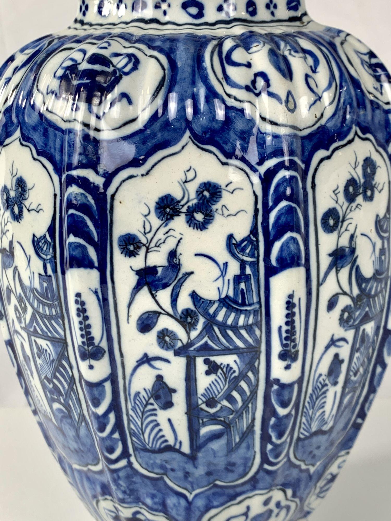 This beautiful blue and white Delft jar was made in the Netherlands circa 1800.
The jar is expertly hand-painted in deep cobalt blue with panels showing a chinoiserie scene.
We see a pagoda with a songbird in a flower-filled garden.
The shape of