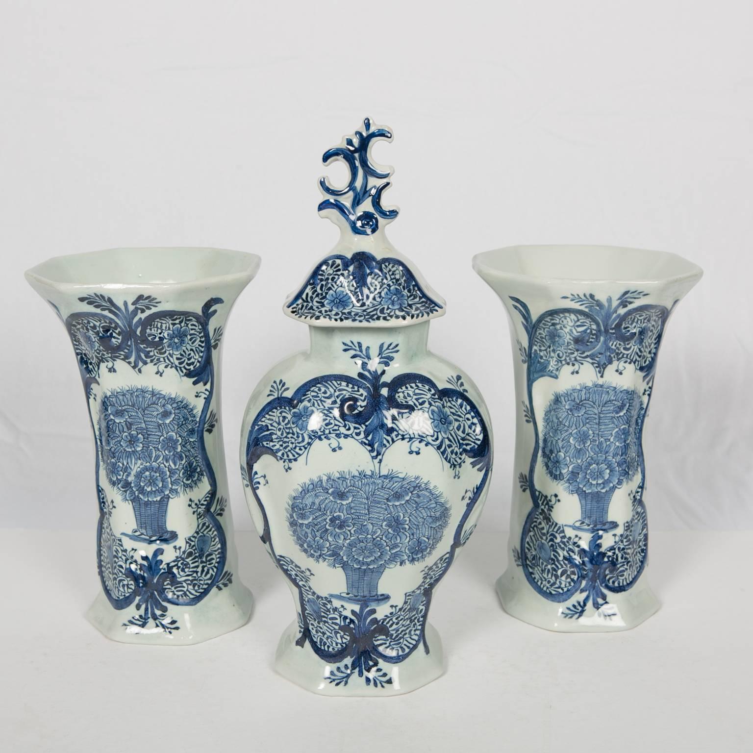Made in the mid 18th century this blue and white Delft three piece mantle garniture is painted with a traditional design in cobalt blue. Made by the Dutch Delft factory 
