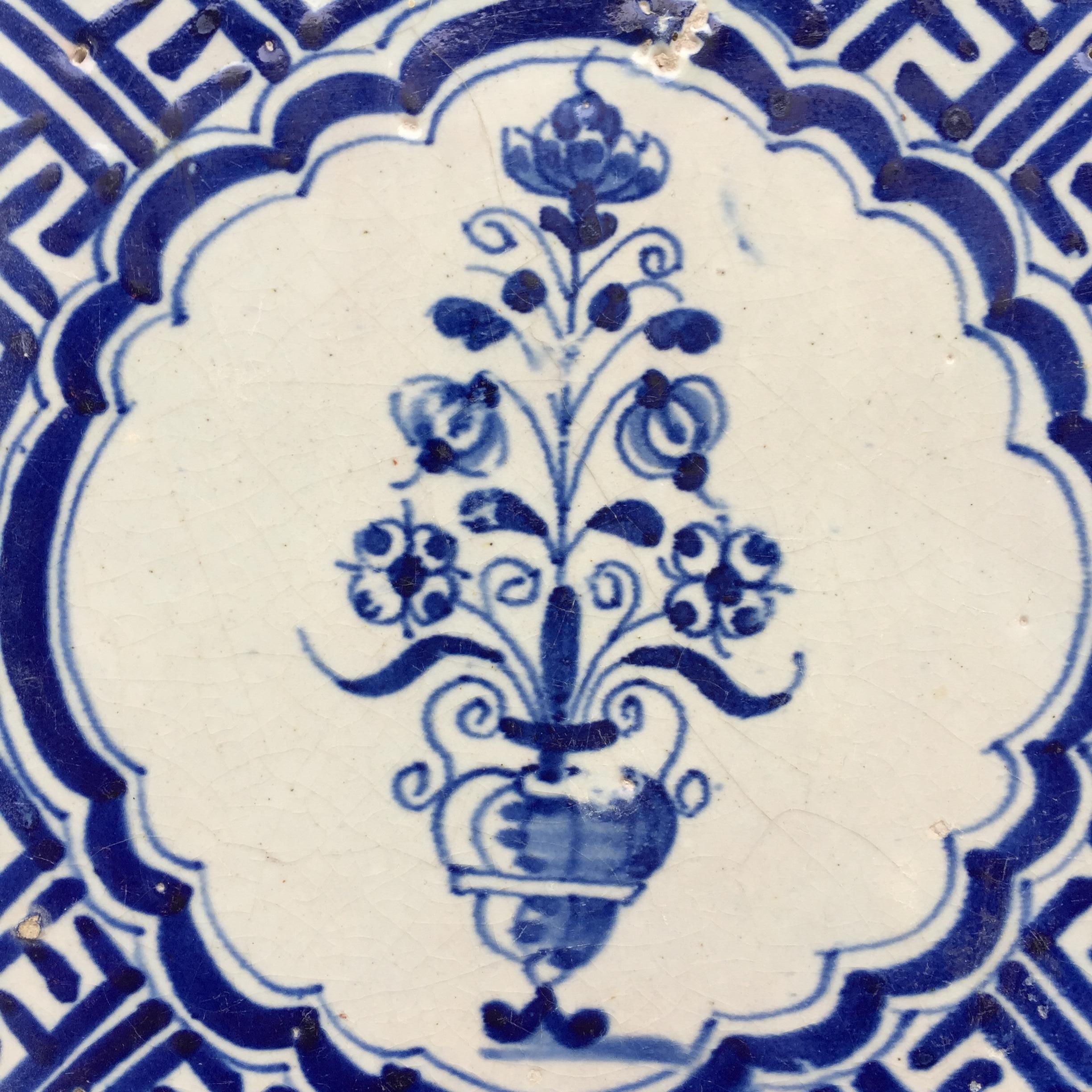 Les Pays-Bas
Vers 1620 - 1640

Un carreau hollandais bleu et blanc à la décoration d'un vase avec des fleurs.
La scène est peinte à l'intérieur d'un cartouche avec un motif d'angle Wanli, inspiré de la porcelaine chinoise de la période